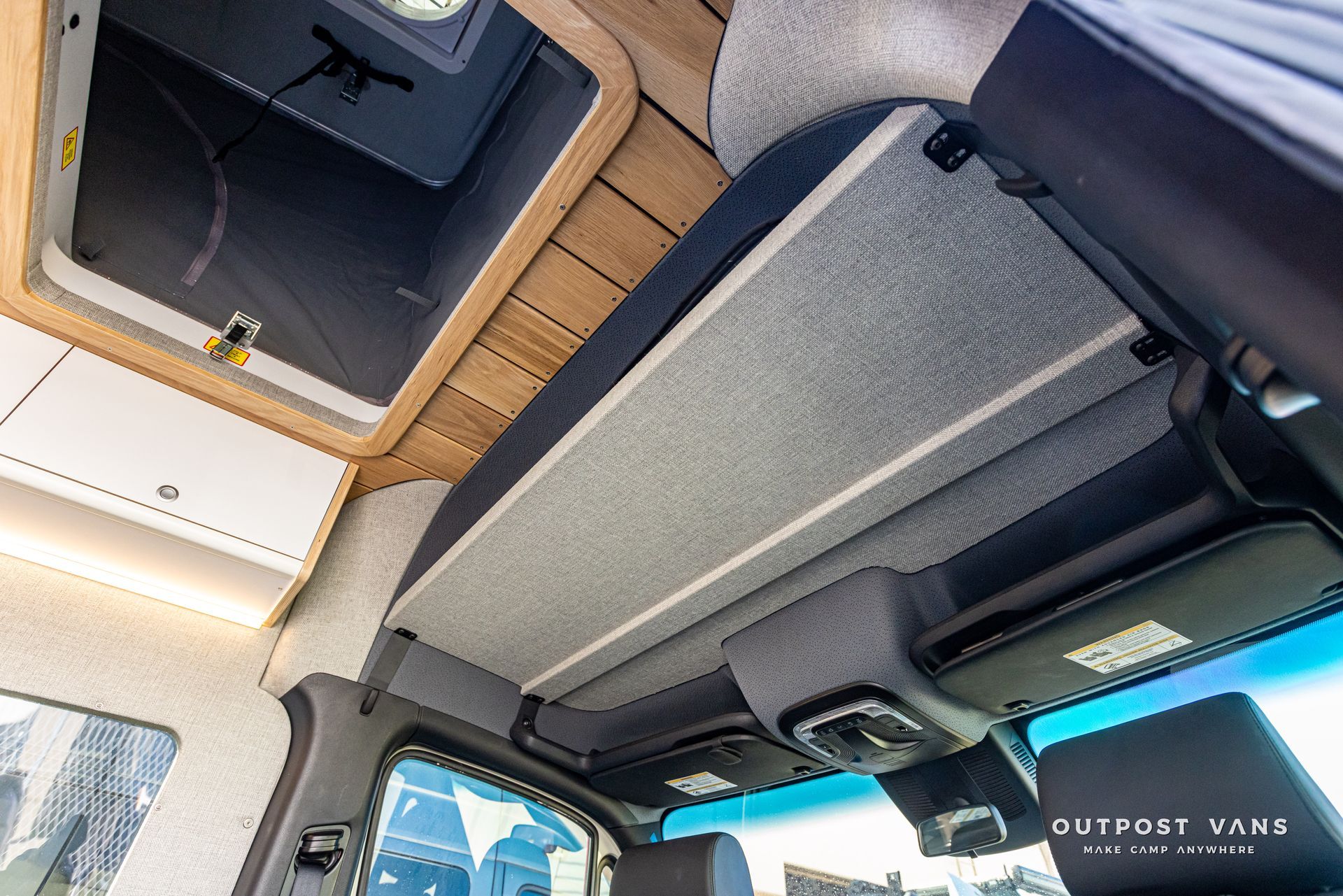 The ceiling of a van with a shelf in it.