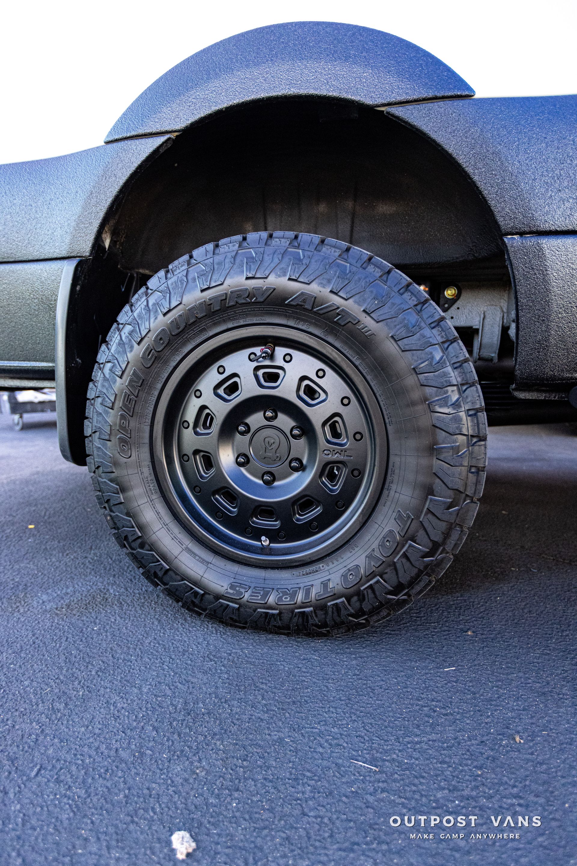 A close up of a truck 's tire on a road.