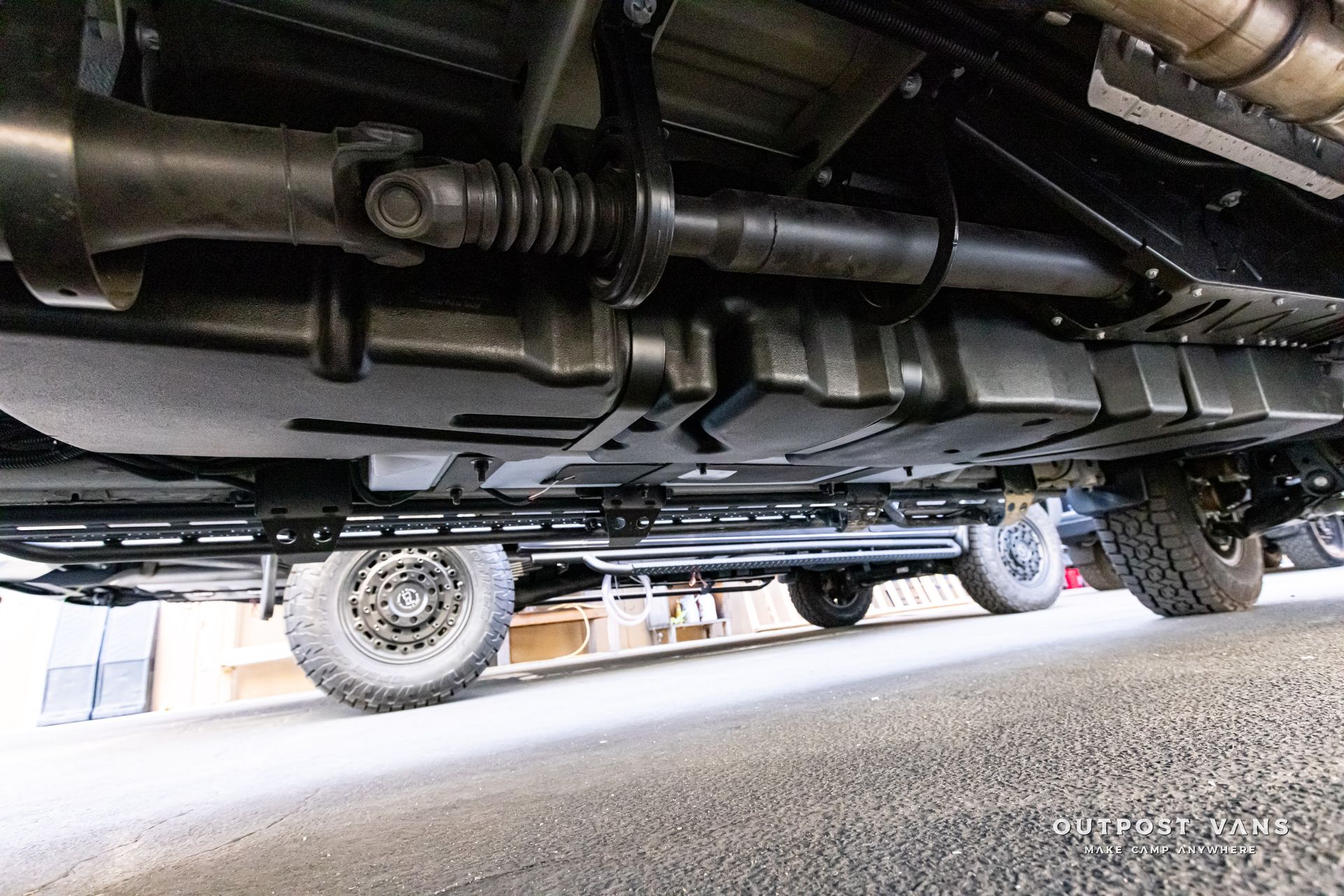 A close up of the underside of a truck parked on the side of the road.