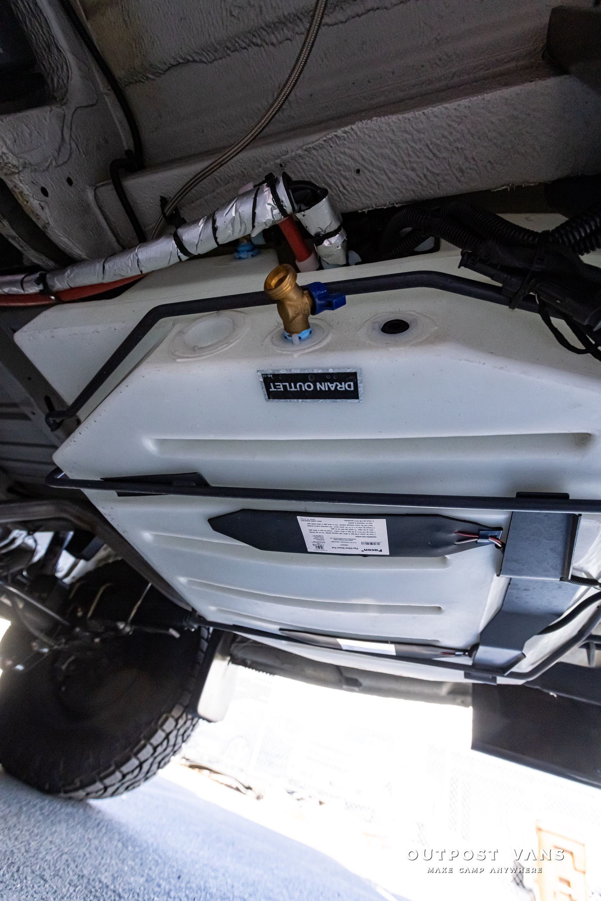 The underside of a vehicle with a fuel tank attached to it.