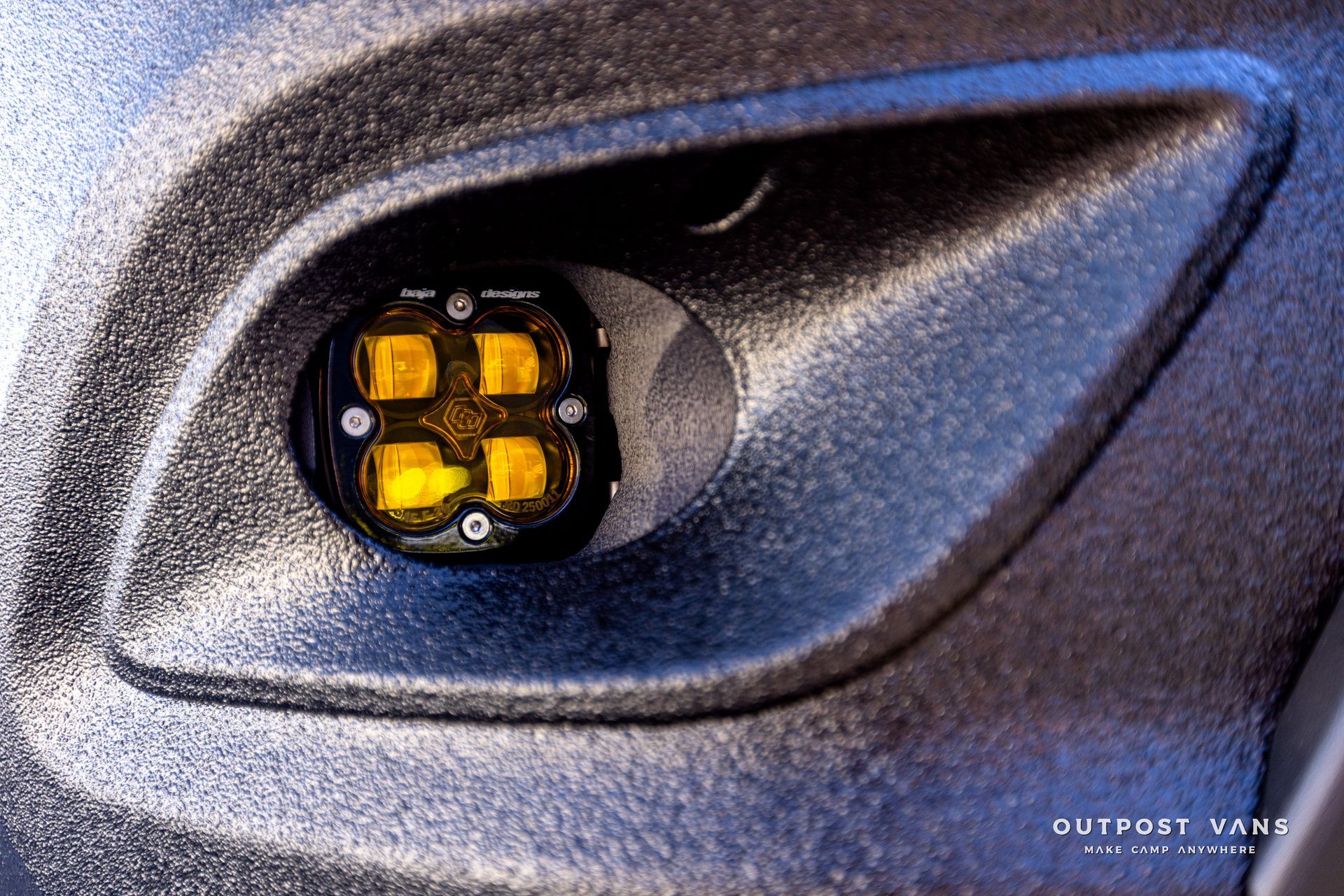 A close up of a fog light on the side of a car.