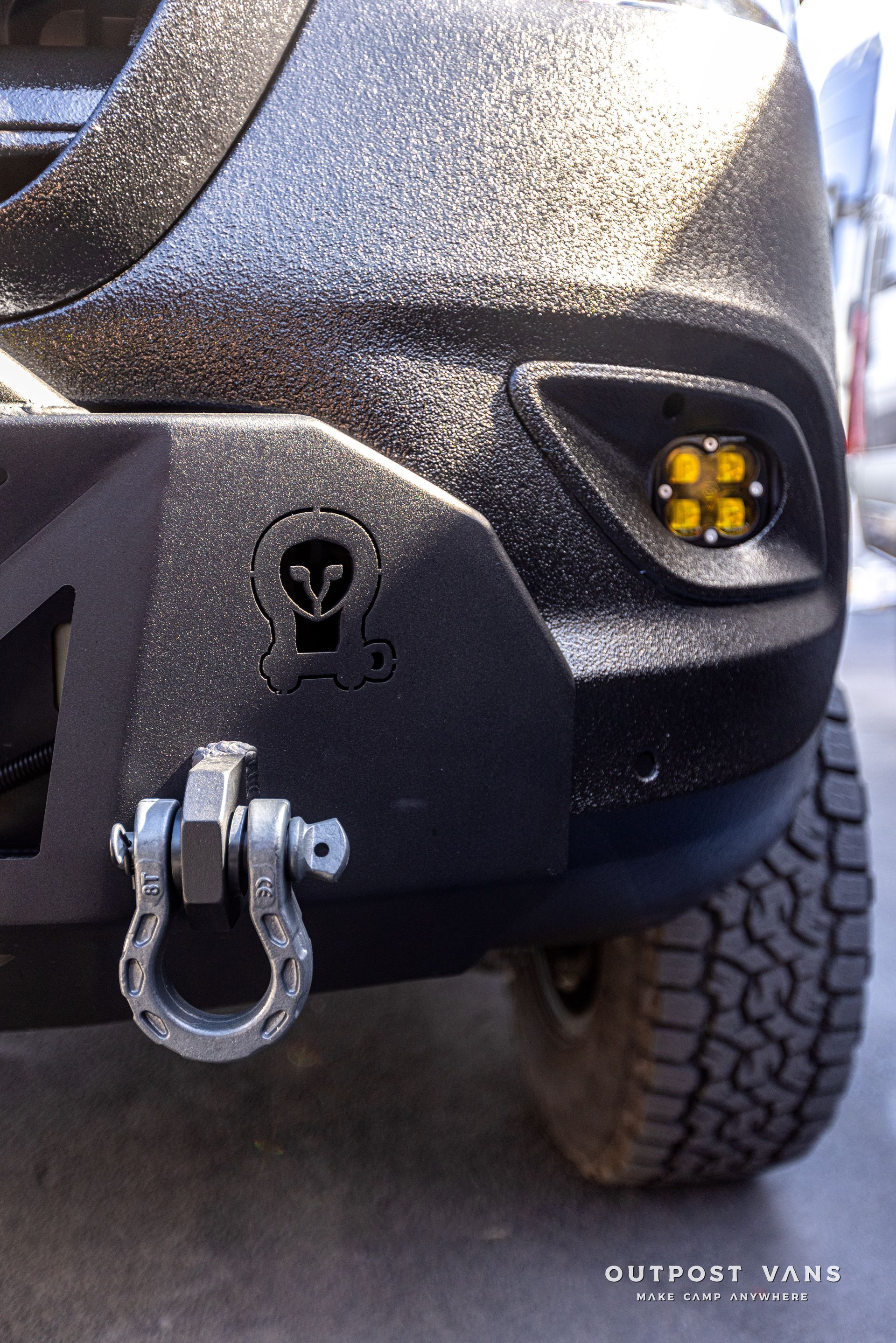 A close up of a car 's bumper with a tow hook attached to it.