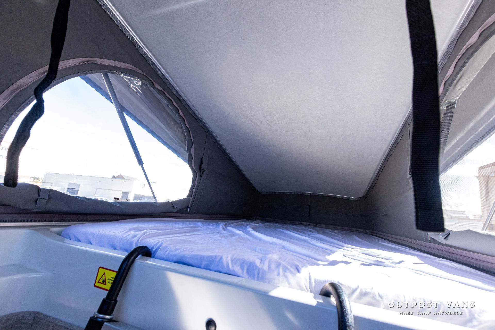 The inside of a camper with a blue mattress