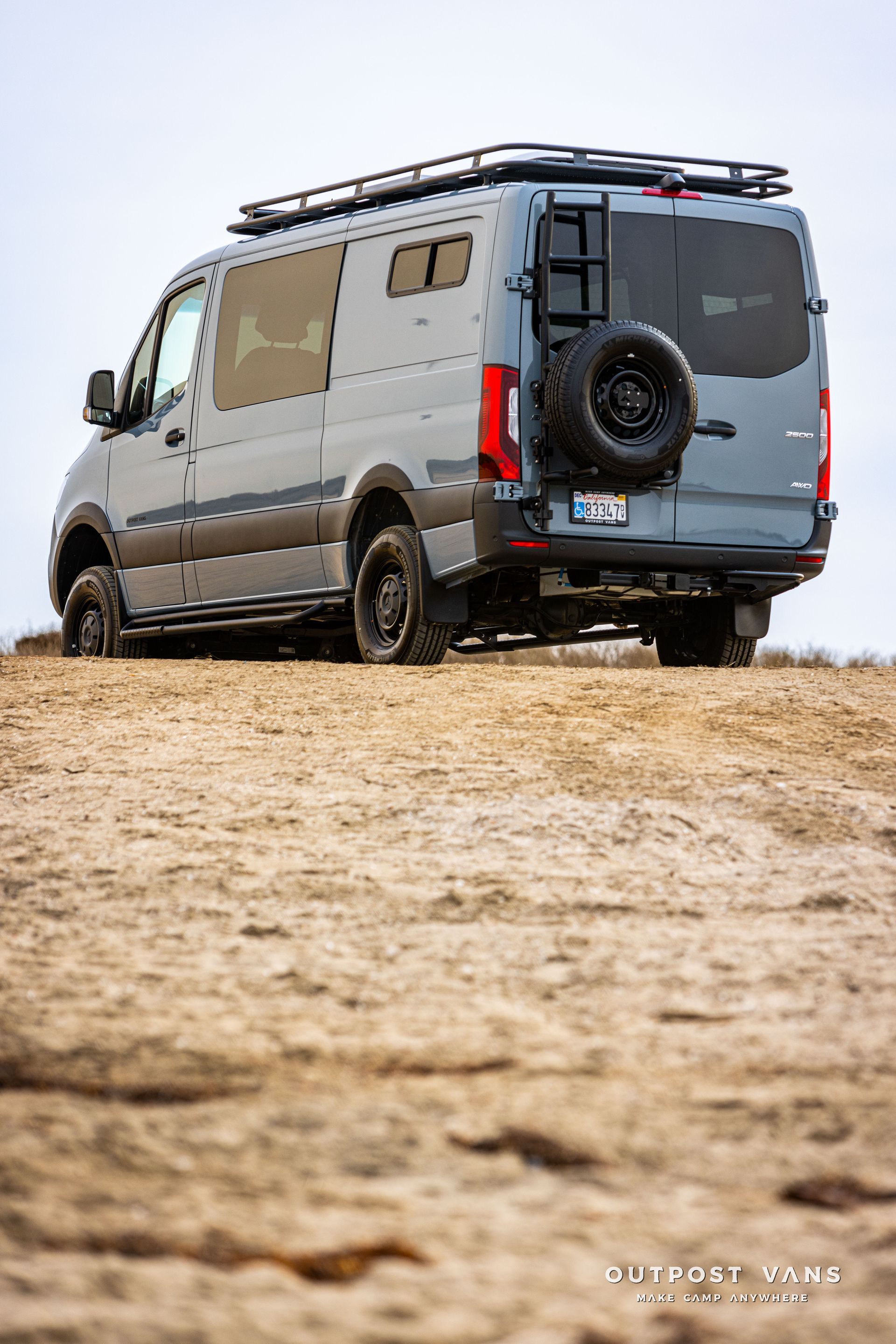 A van is parked on top of a sandy hill.
