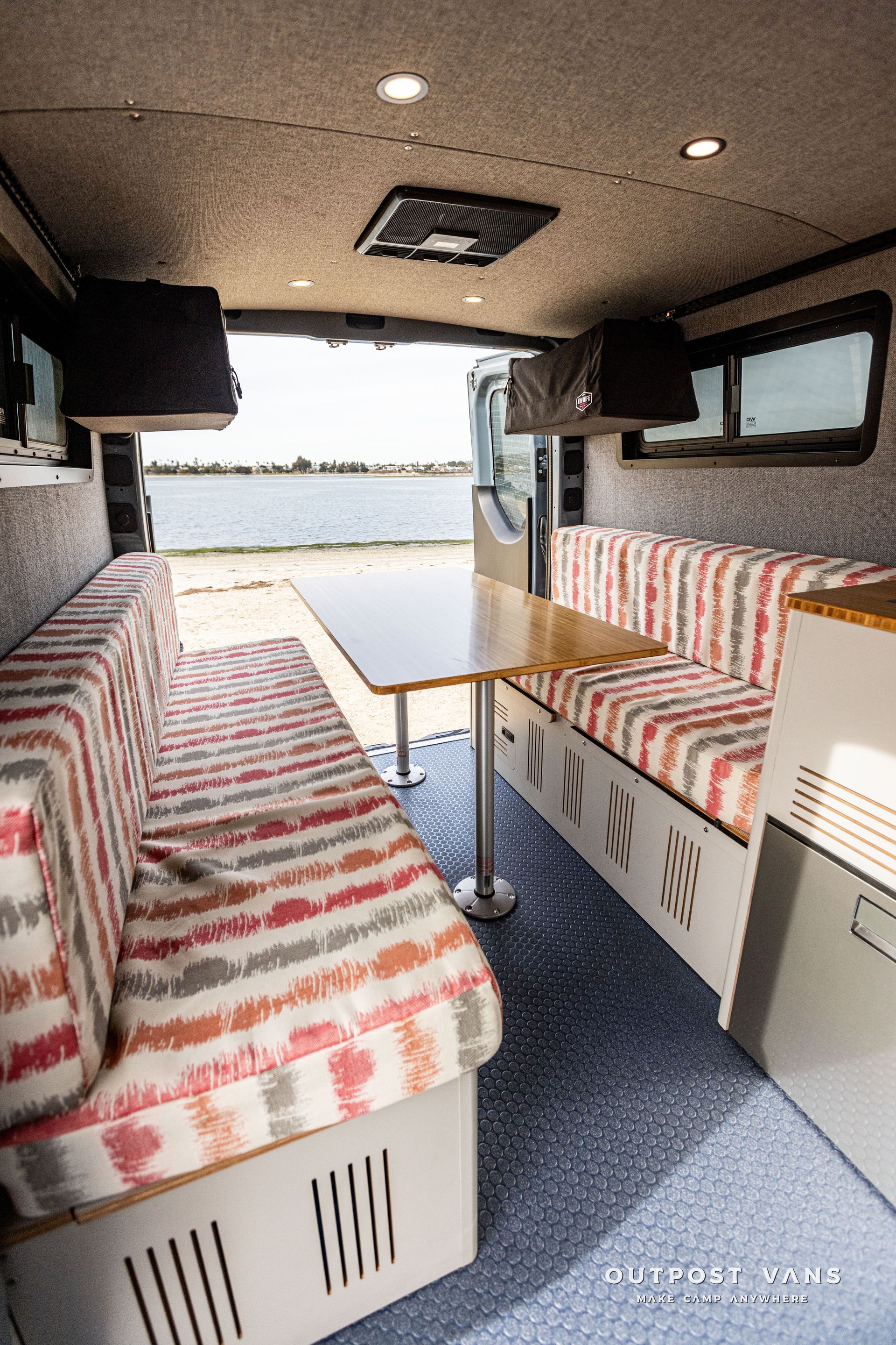 The inside of a camper van with a table and couch.