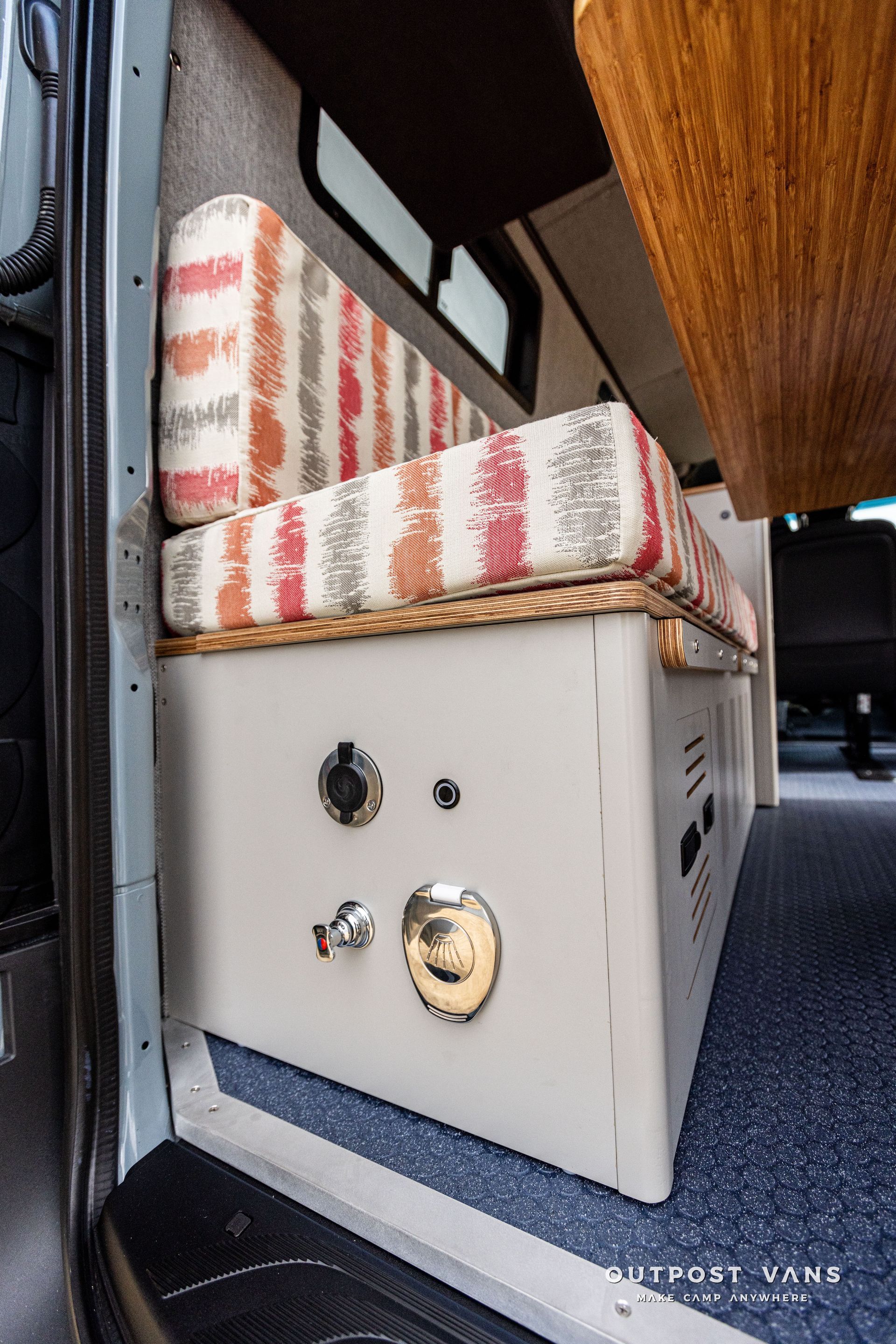 A camper van with a couch and a table in the back.