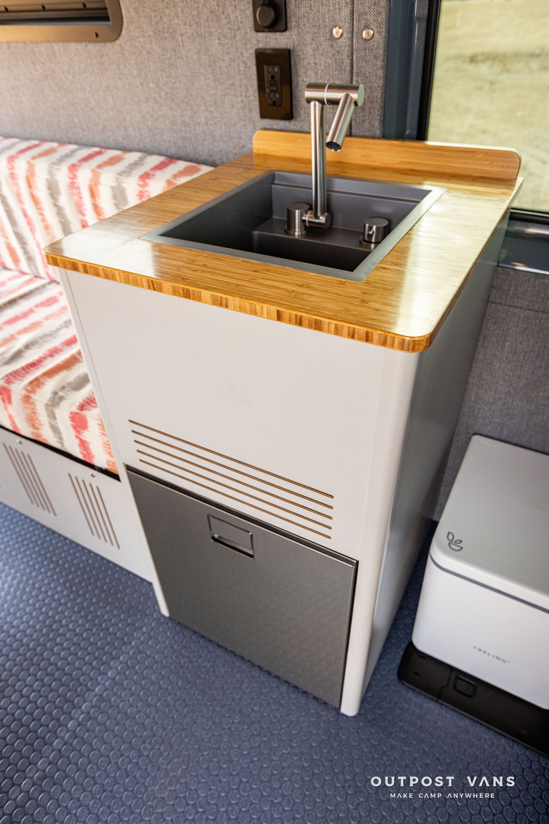 A sink is sitting on top of a counter in a camper van.