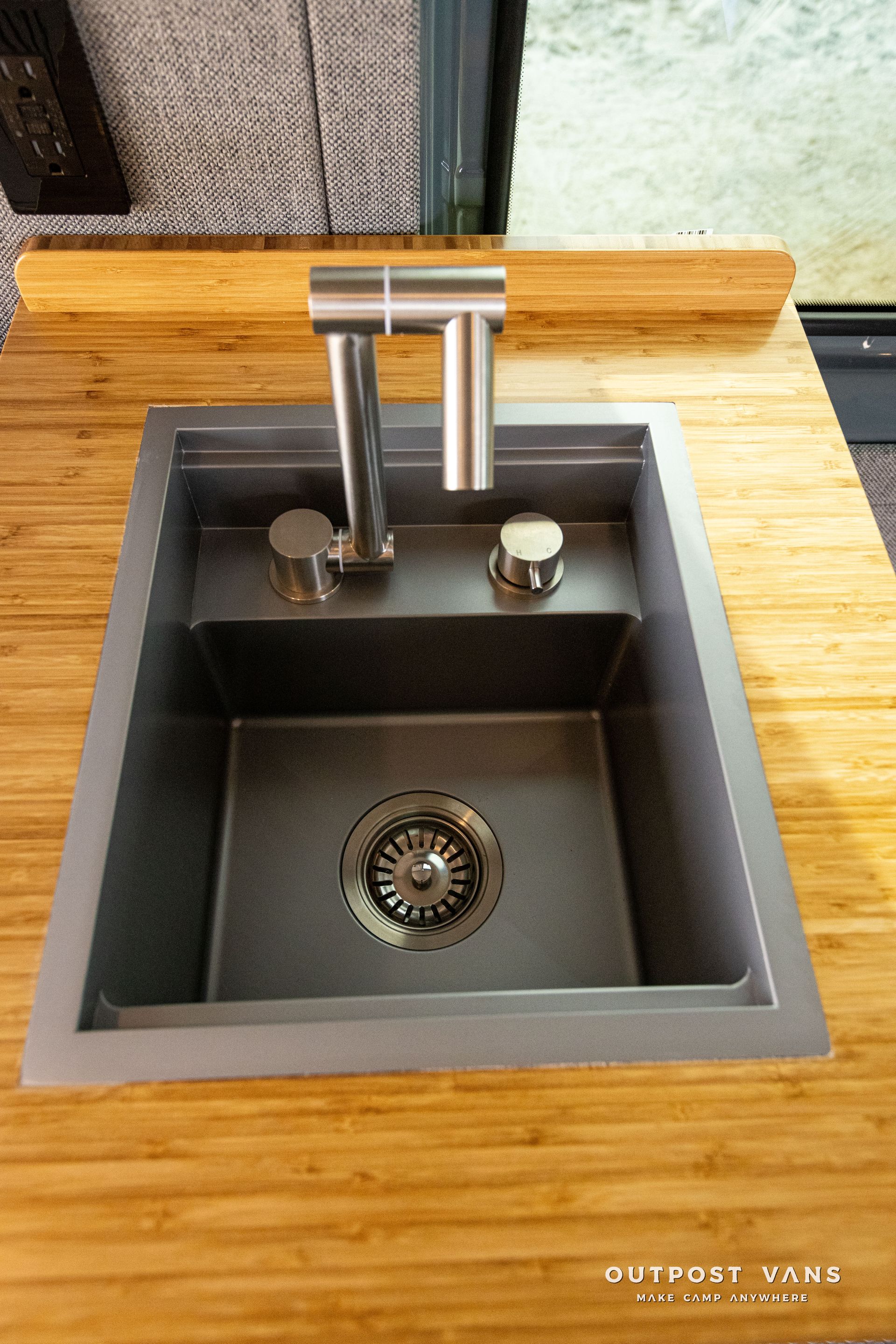 A kitchen sink is sitting on top of a wooden counter.