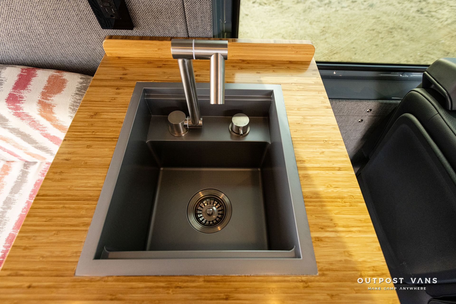 A small sink is sitting on top of a wooden table.