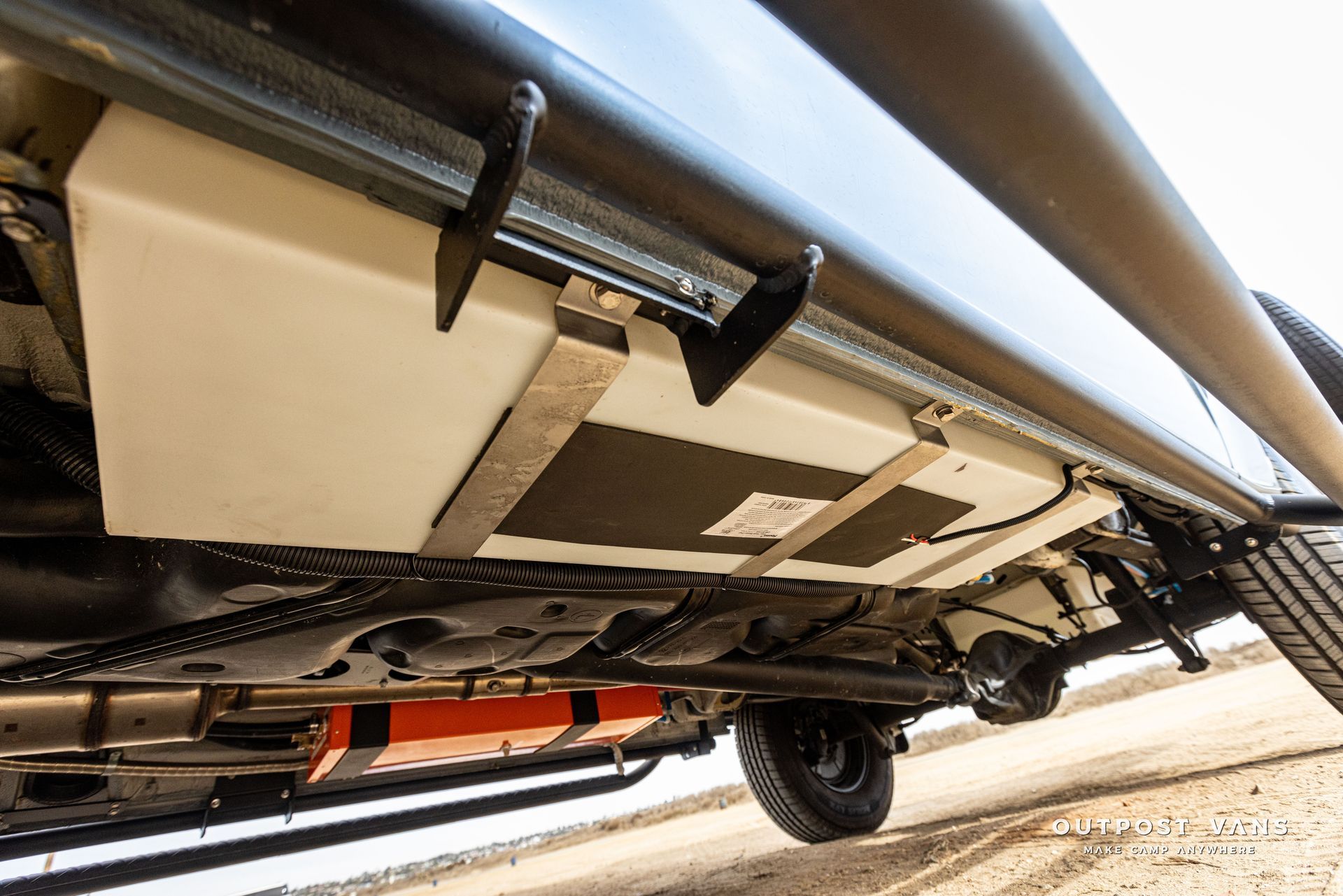 The underside of a truck with a fuel tank attached to it.