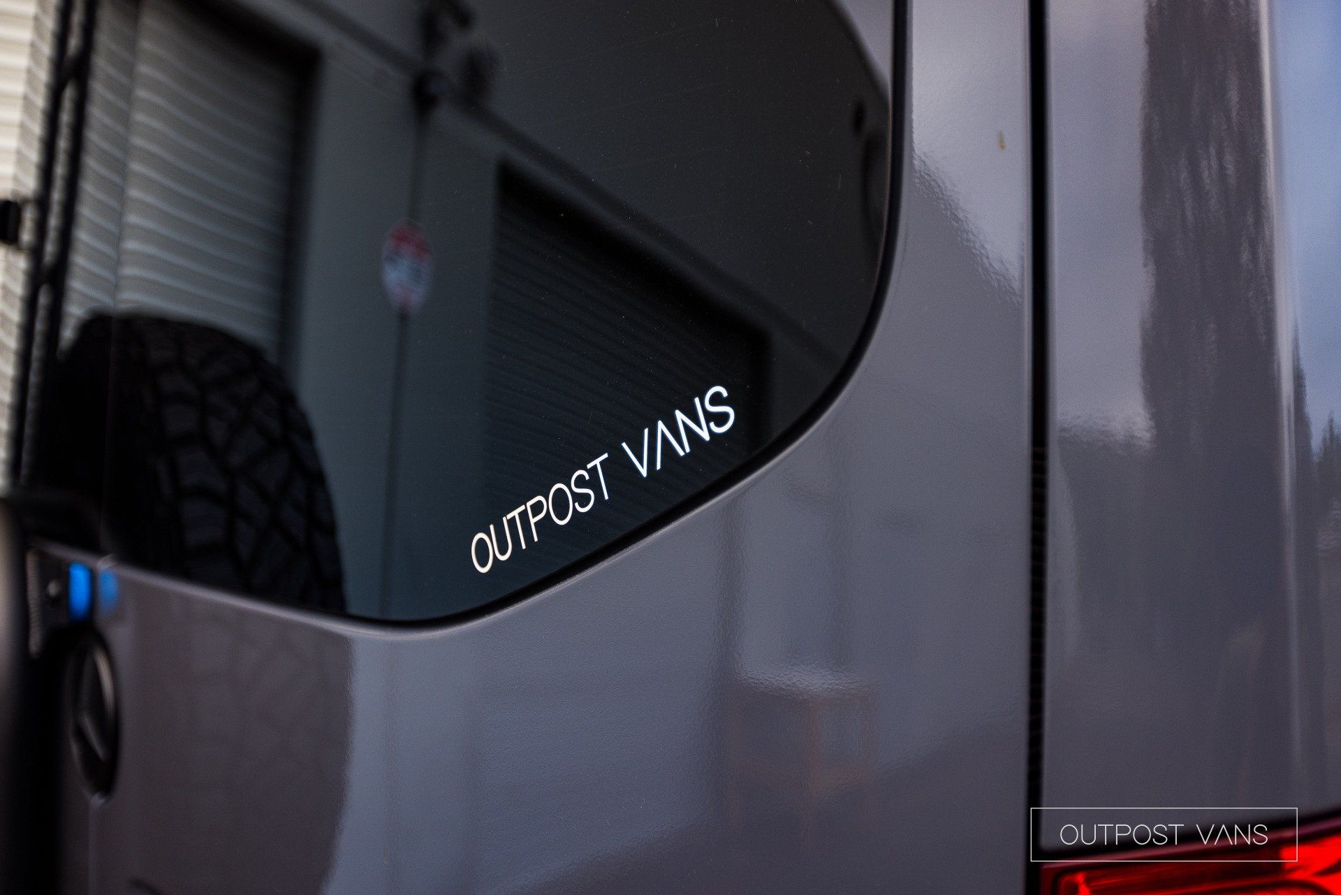 a van with a sticker on the back window that says outpost vans