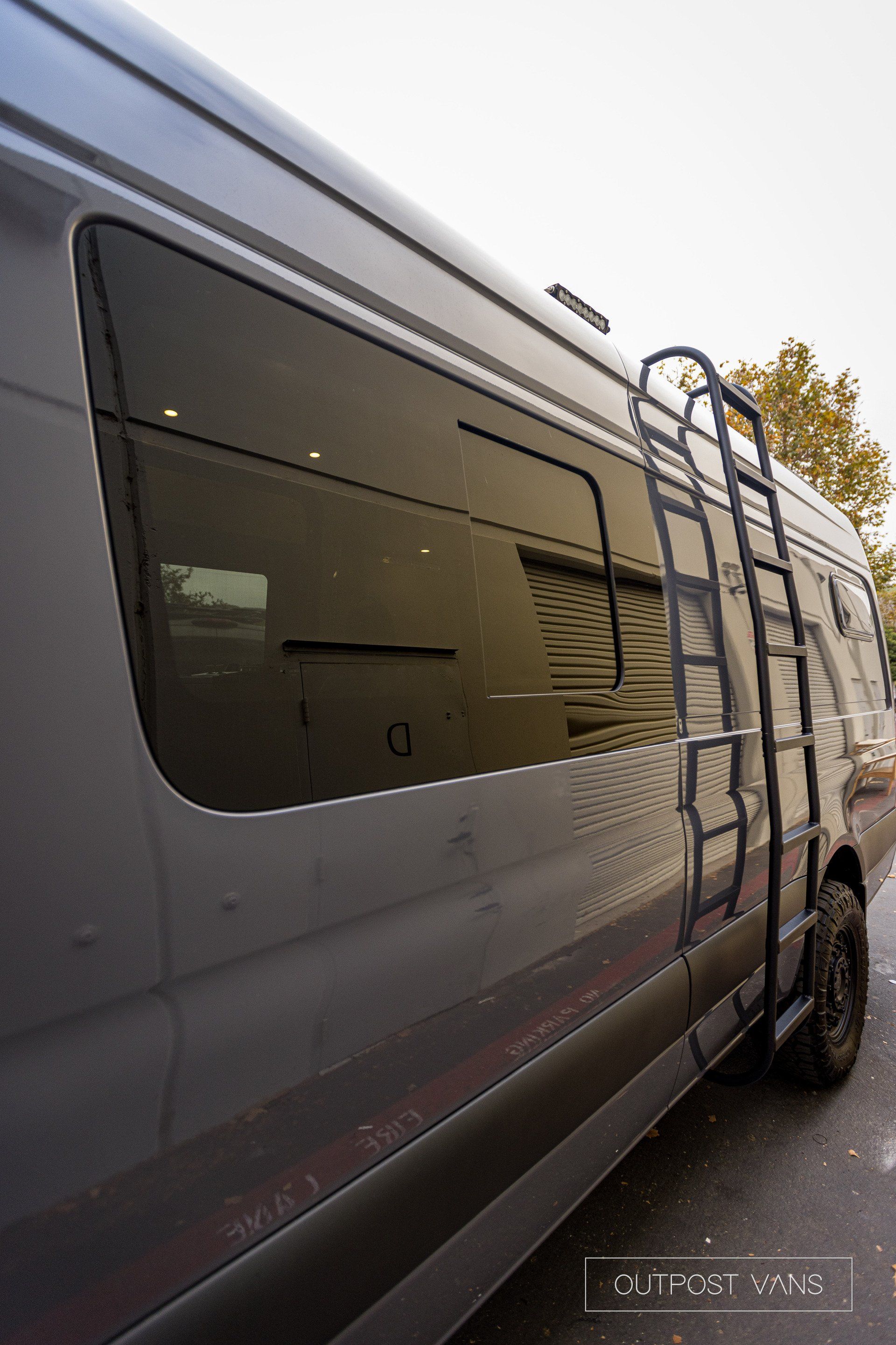 a van with a ladder attached to the side of it .