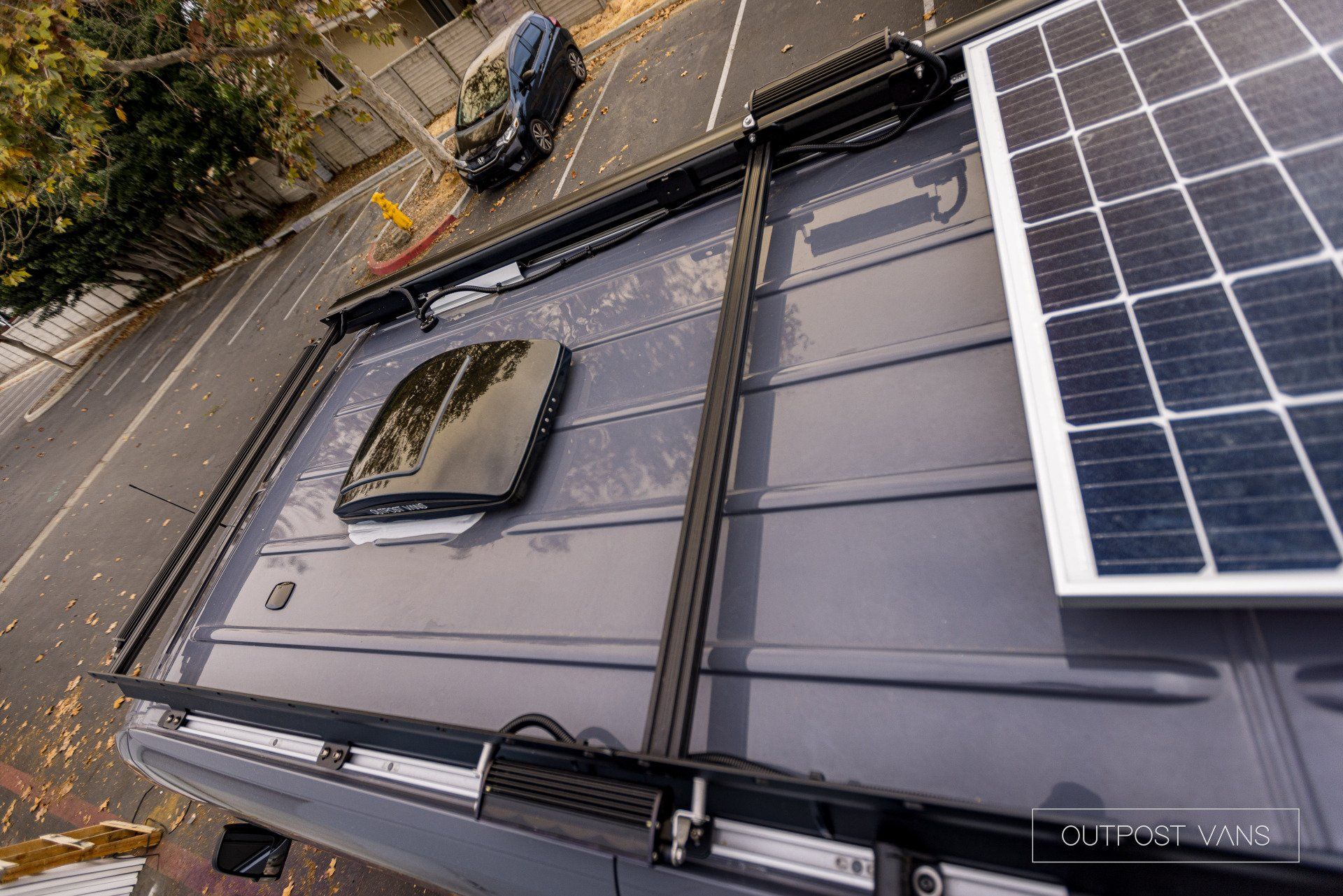 An aerial view of a van with solar panels on the roof.