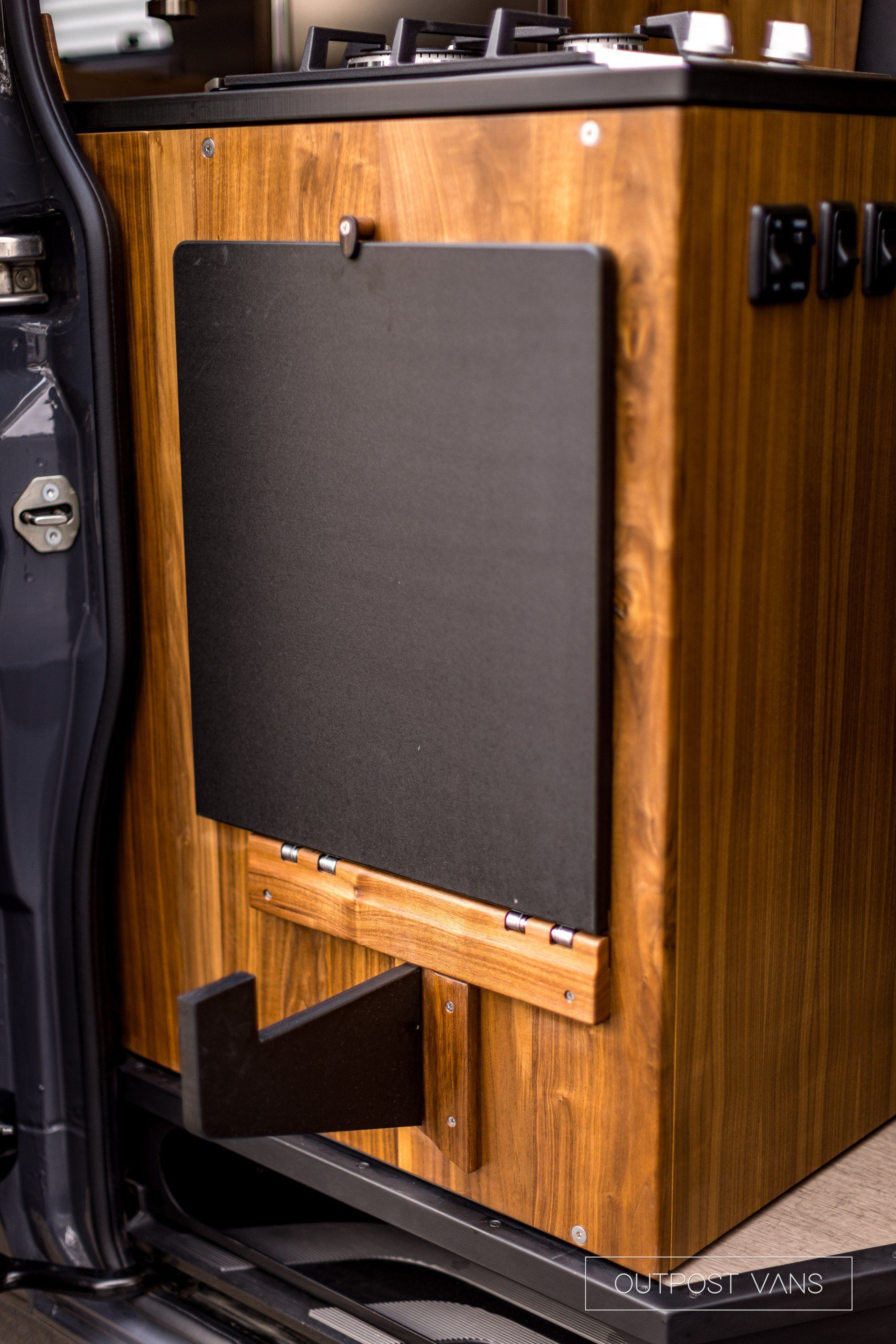 A wooden cabinet with a black board attached to it.