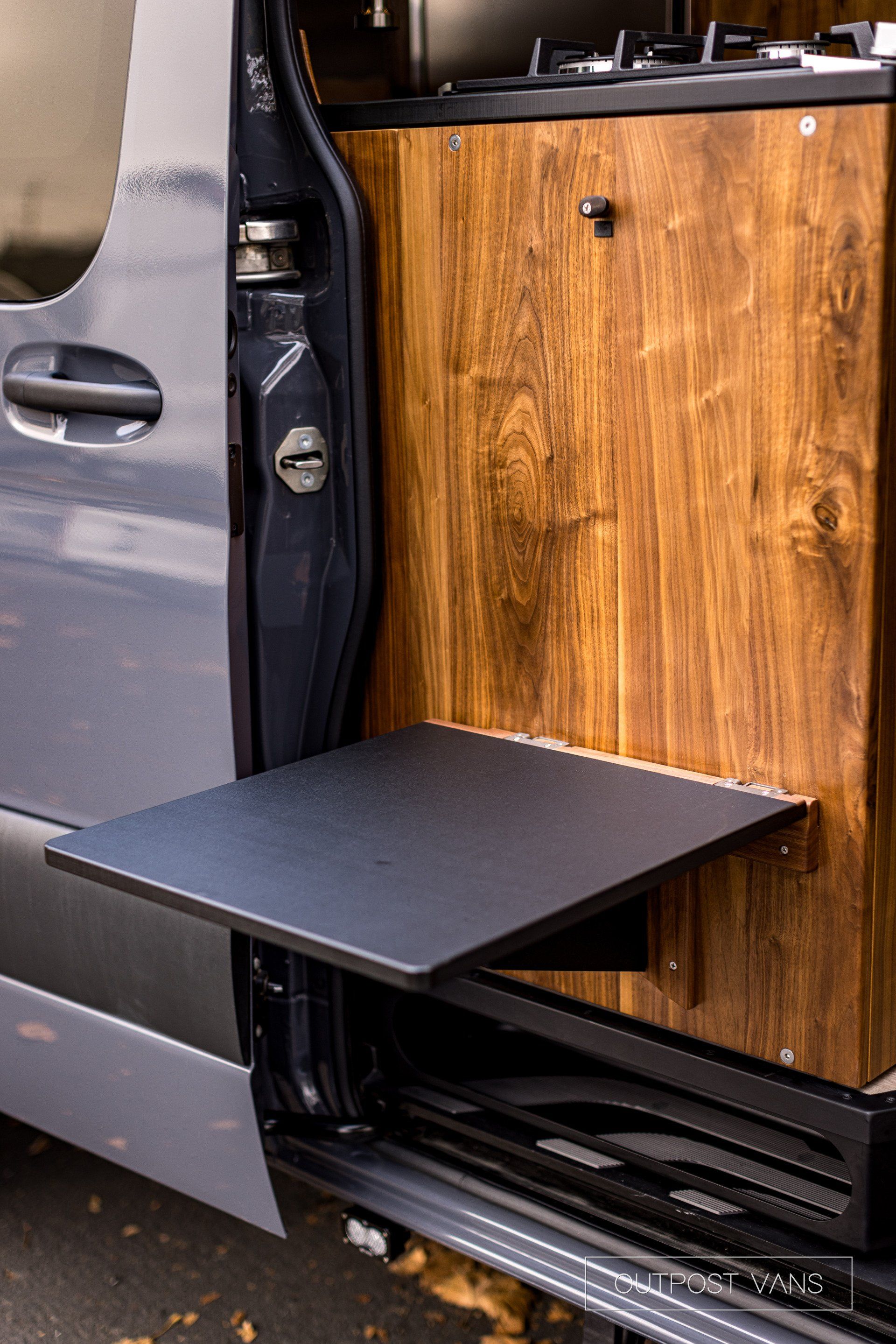 A van with a table attached to the side of it.