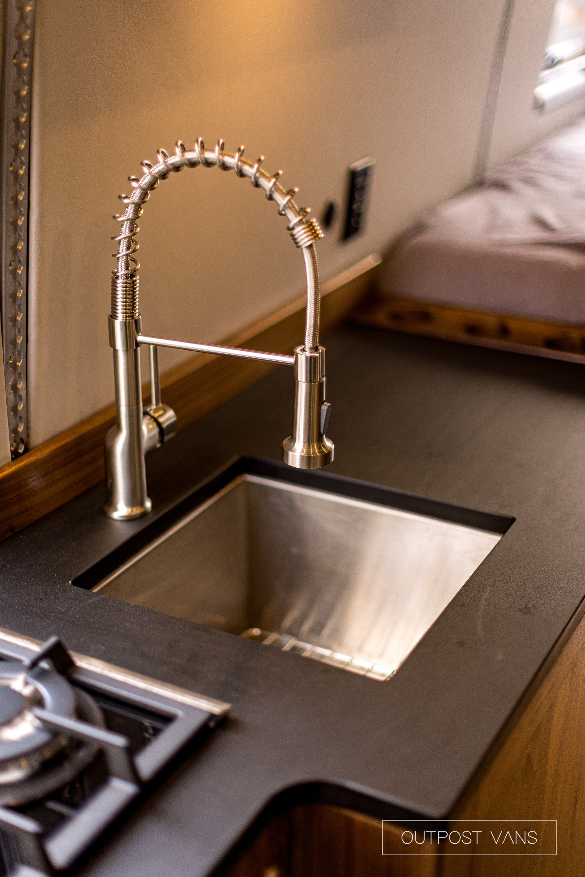 A kitchen sink with a stainless steel faucet