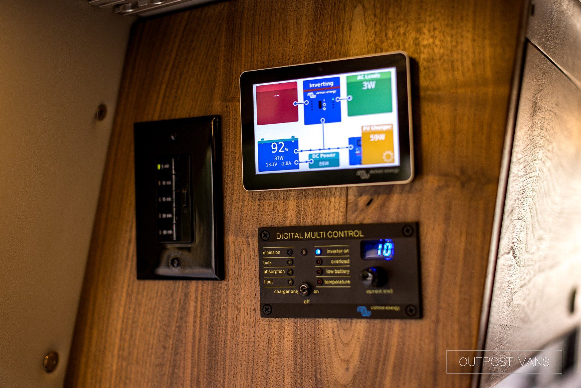 A tablet is sitting on a wooden wall next to a switch.