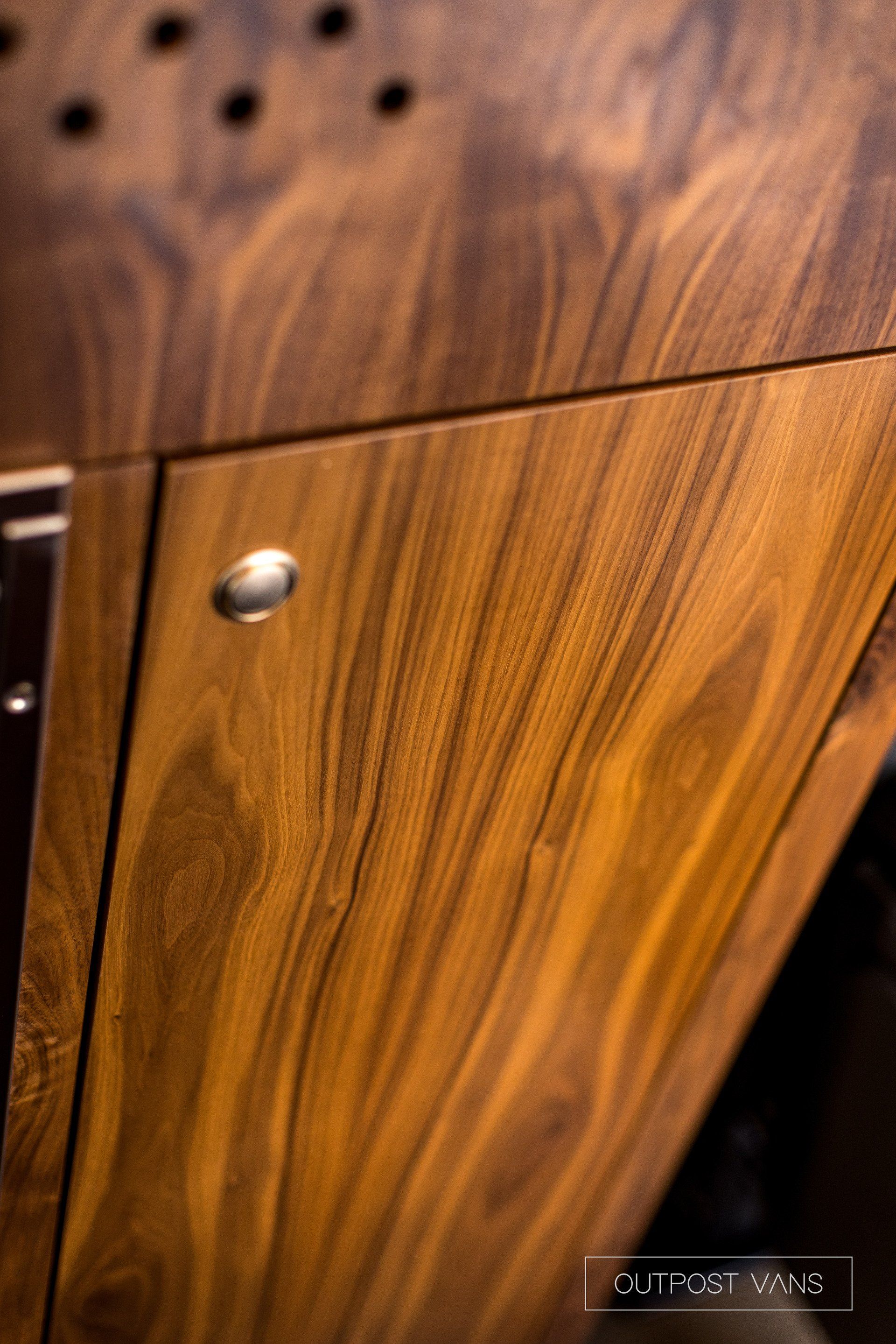 A close up of a wooden cabinet with metal handles