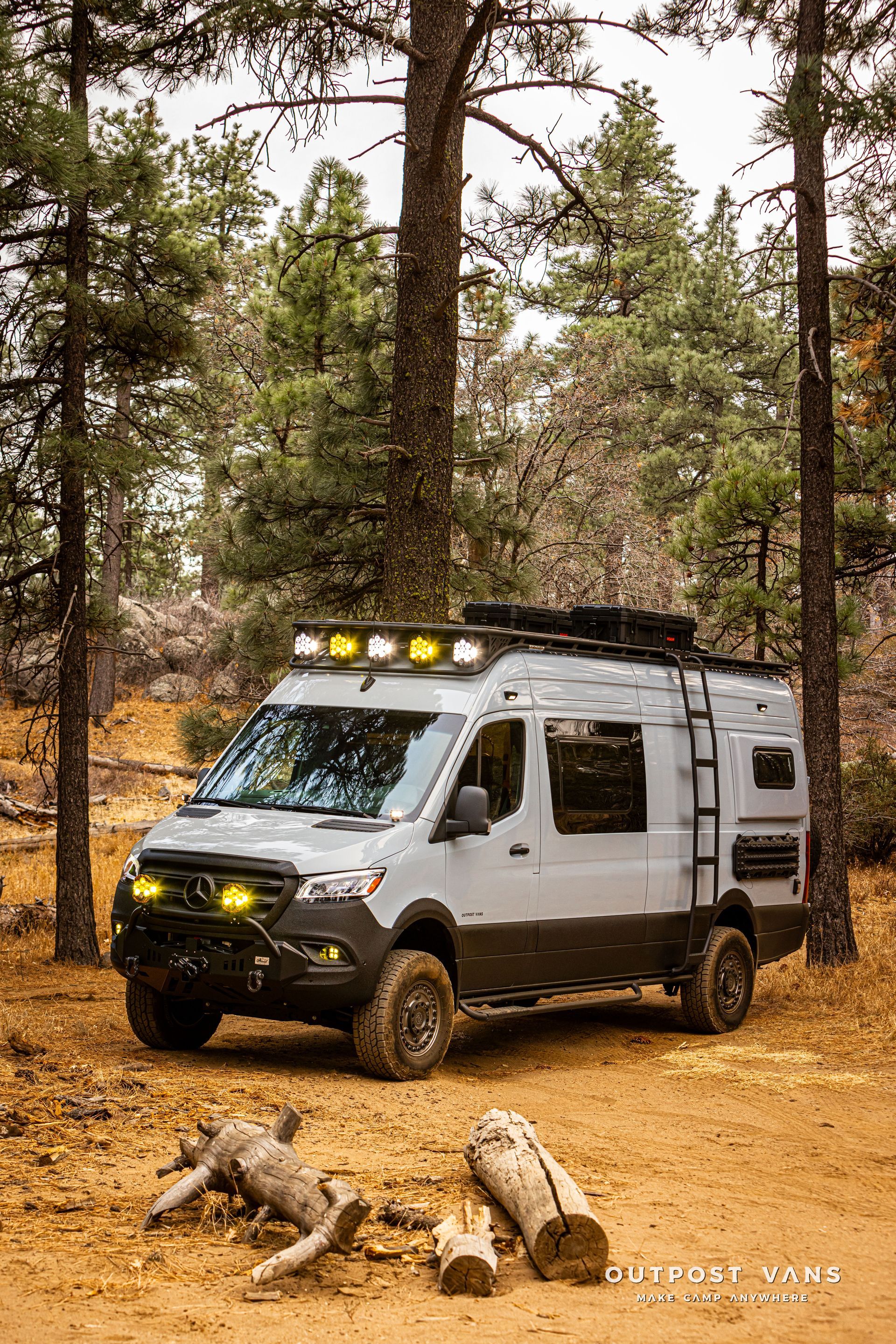 A van is parked in the middle of a forest.