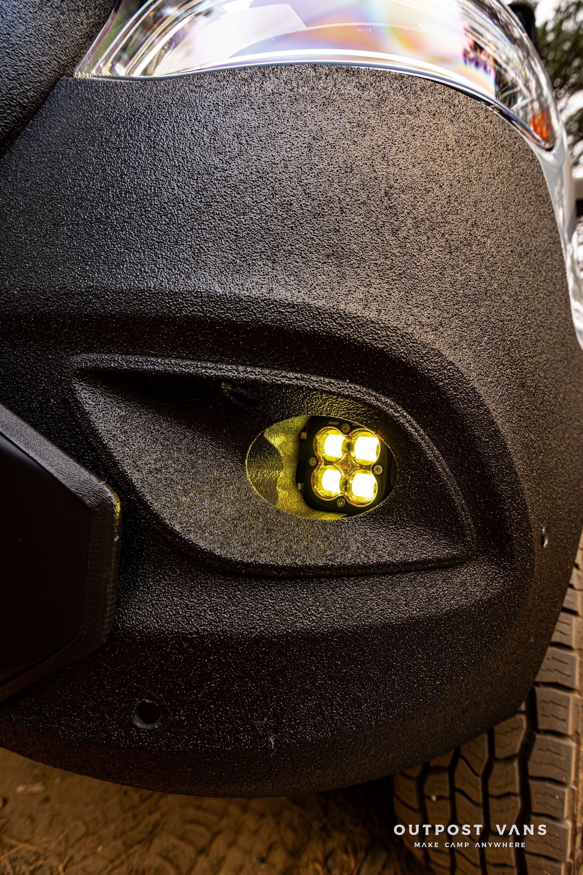 A close up of a black car with a yellow light on it.