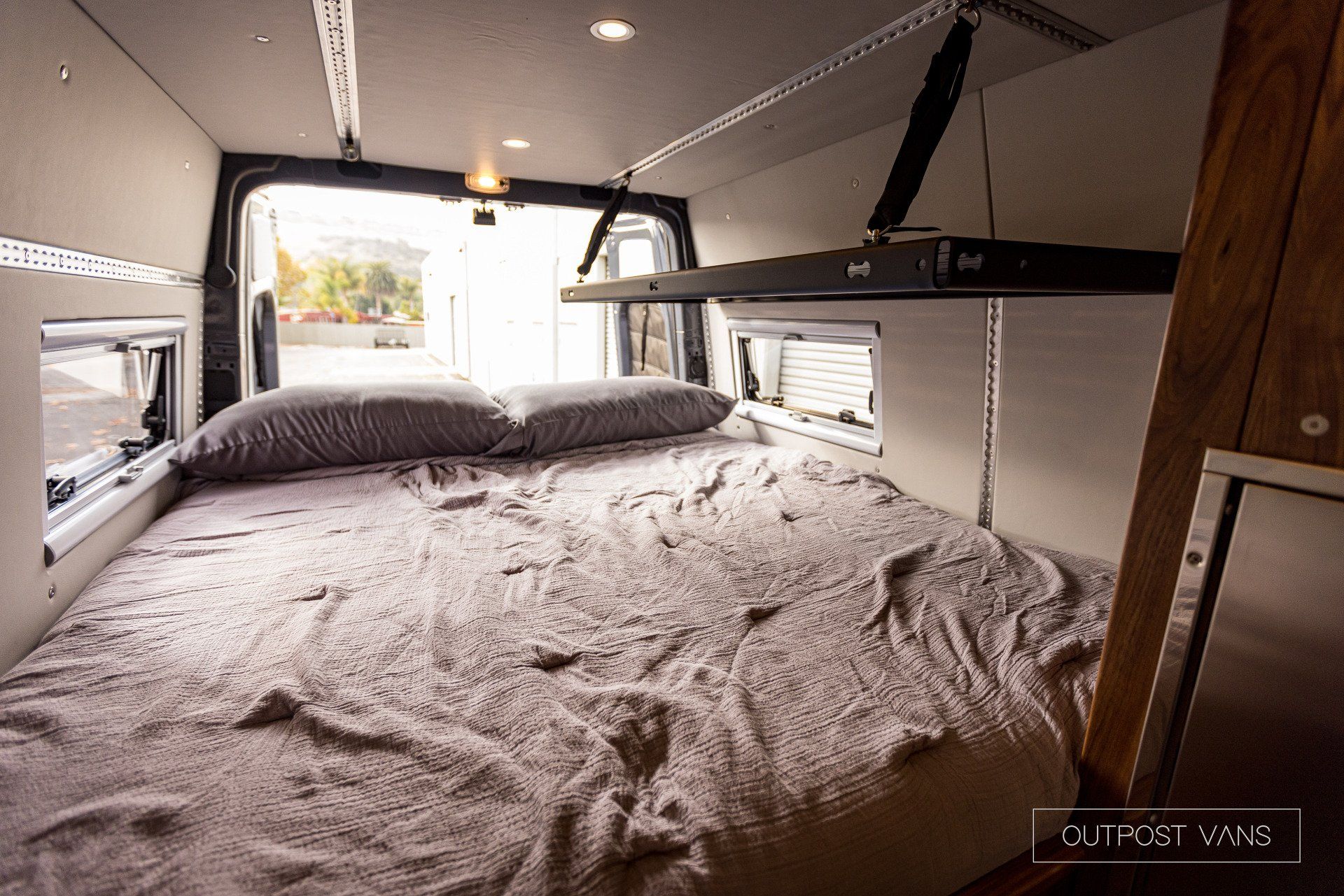 There is a bed in the back of a van.