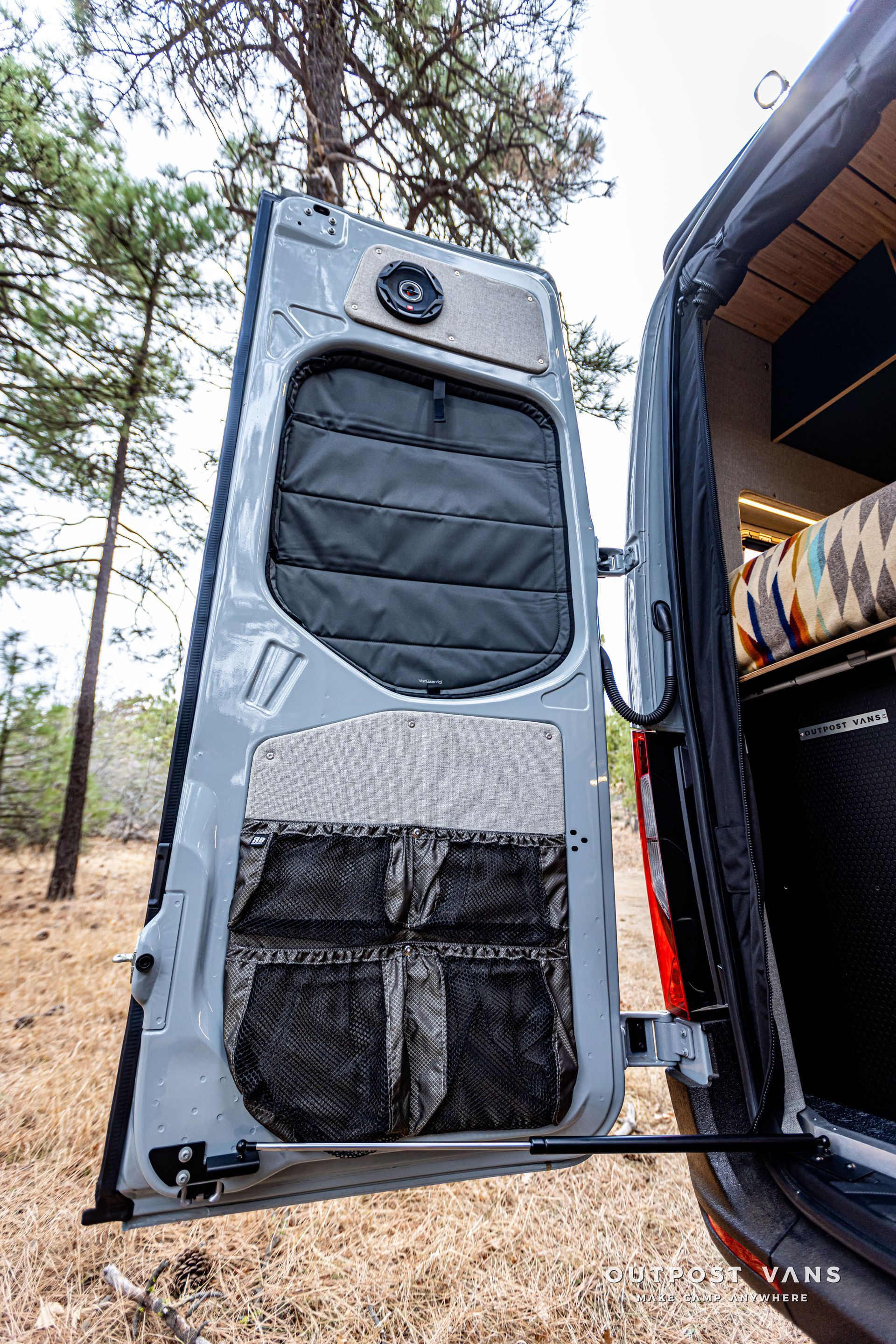 The back door of a van is open in a field.