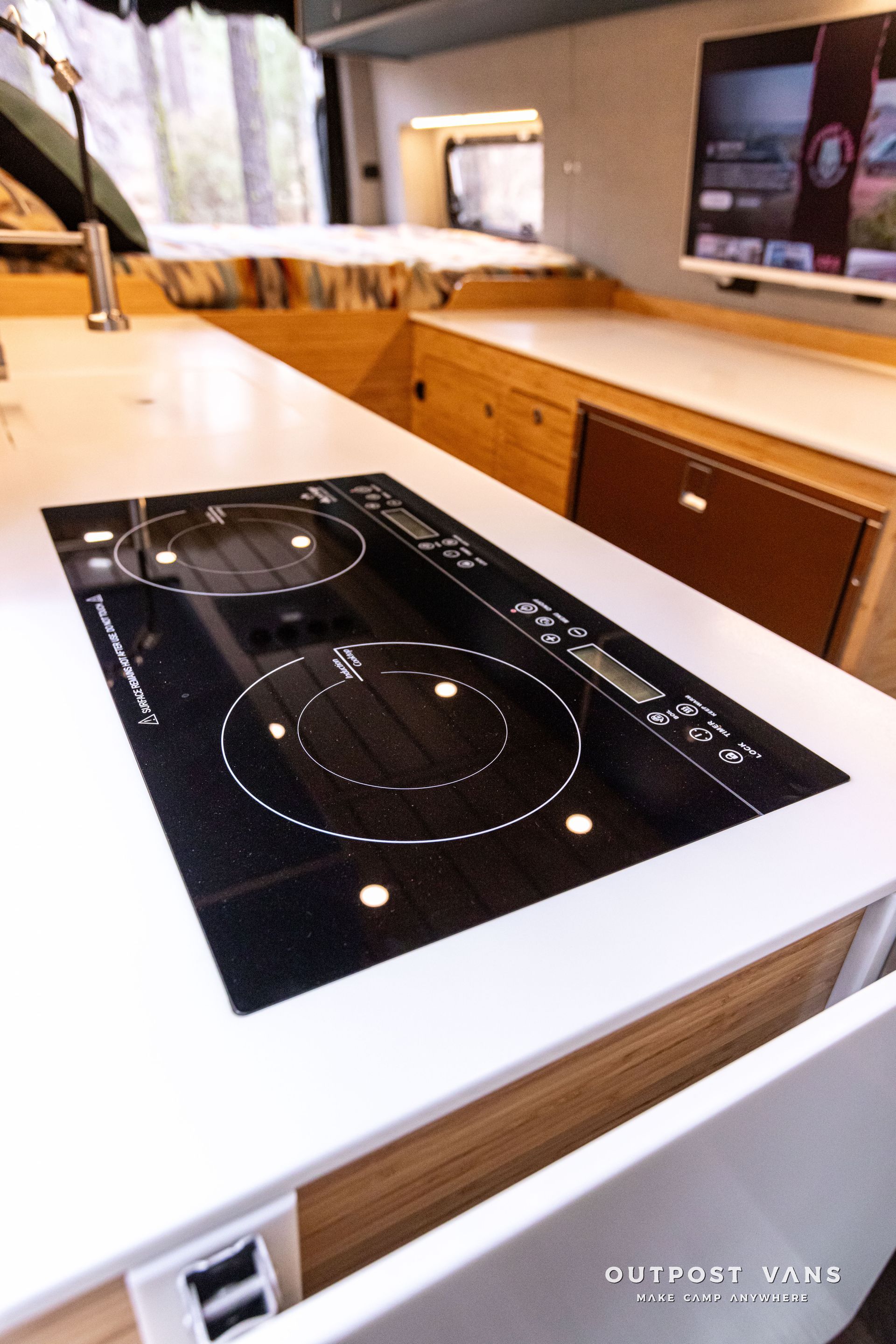 A kitchen with a stove top oven and a television