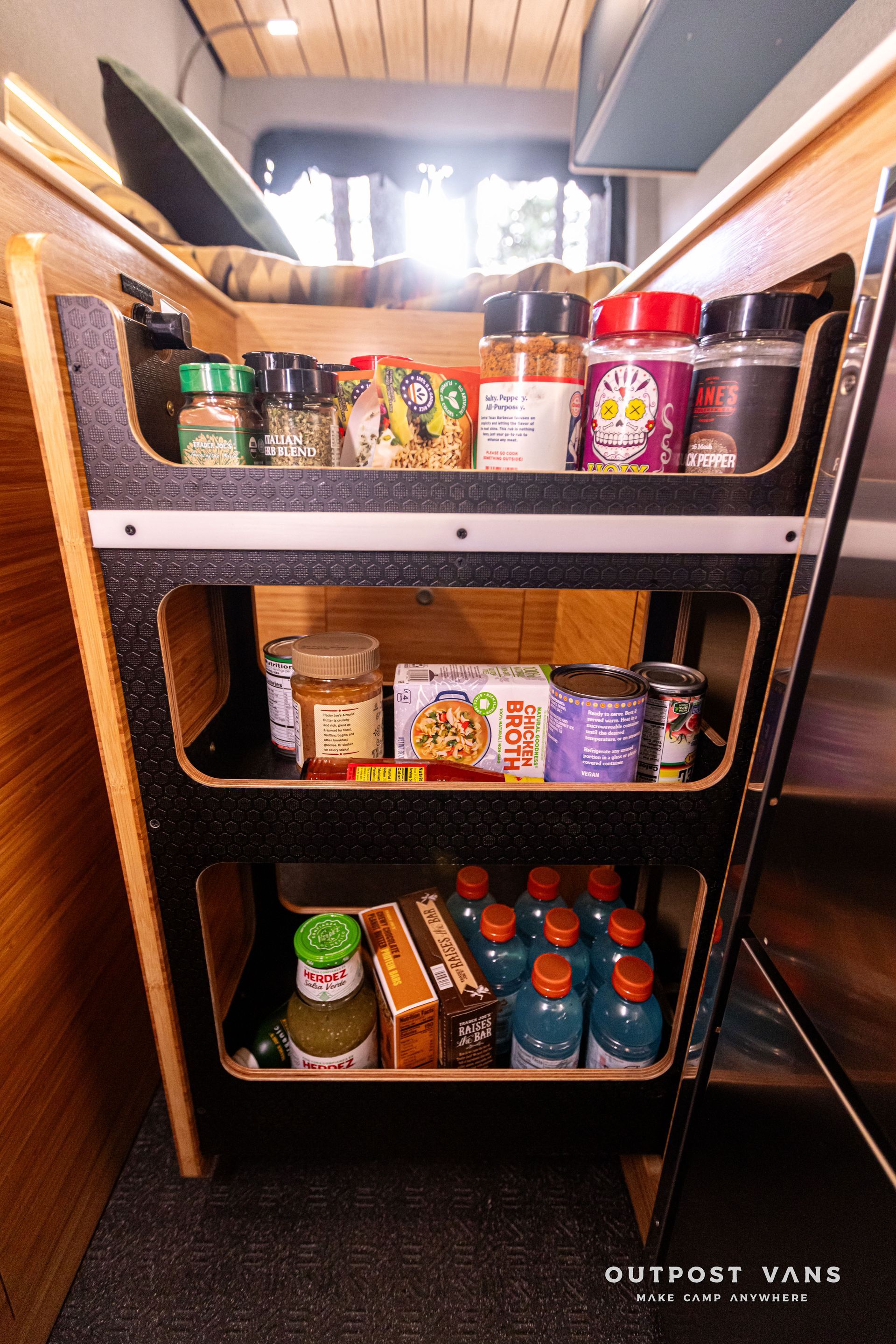 A pantry in a van filled with food and spices