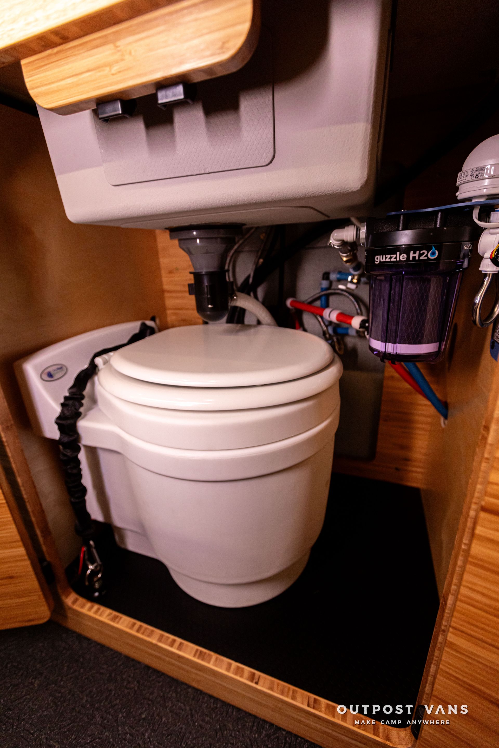 A toilet is sitting under a sink in a bathroom.