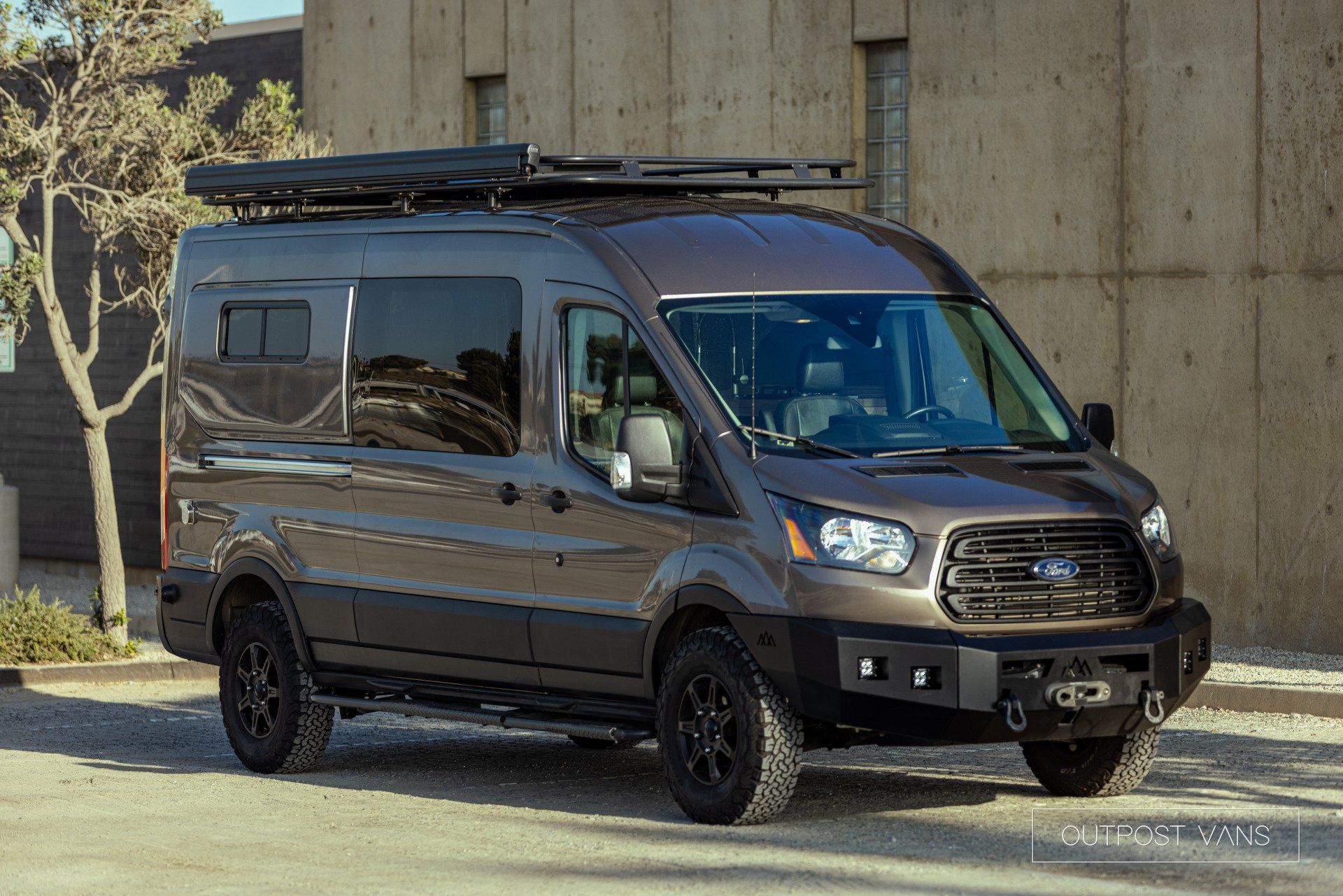 a ford transit van is parked in front of a building .