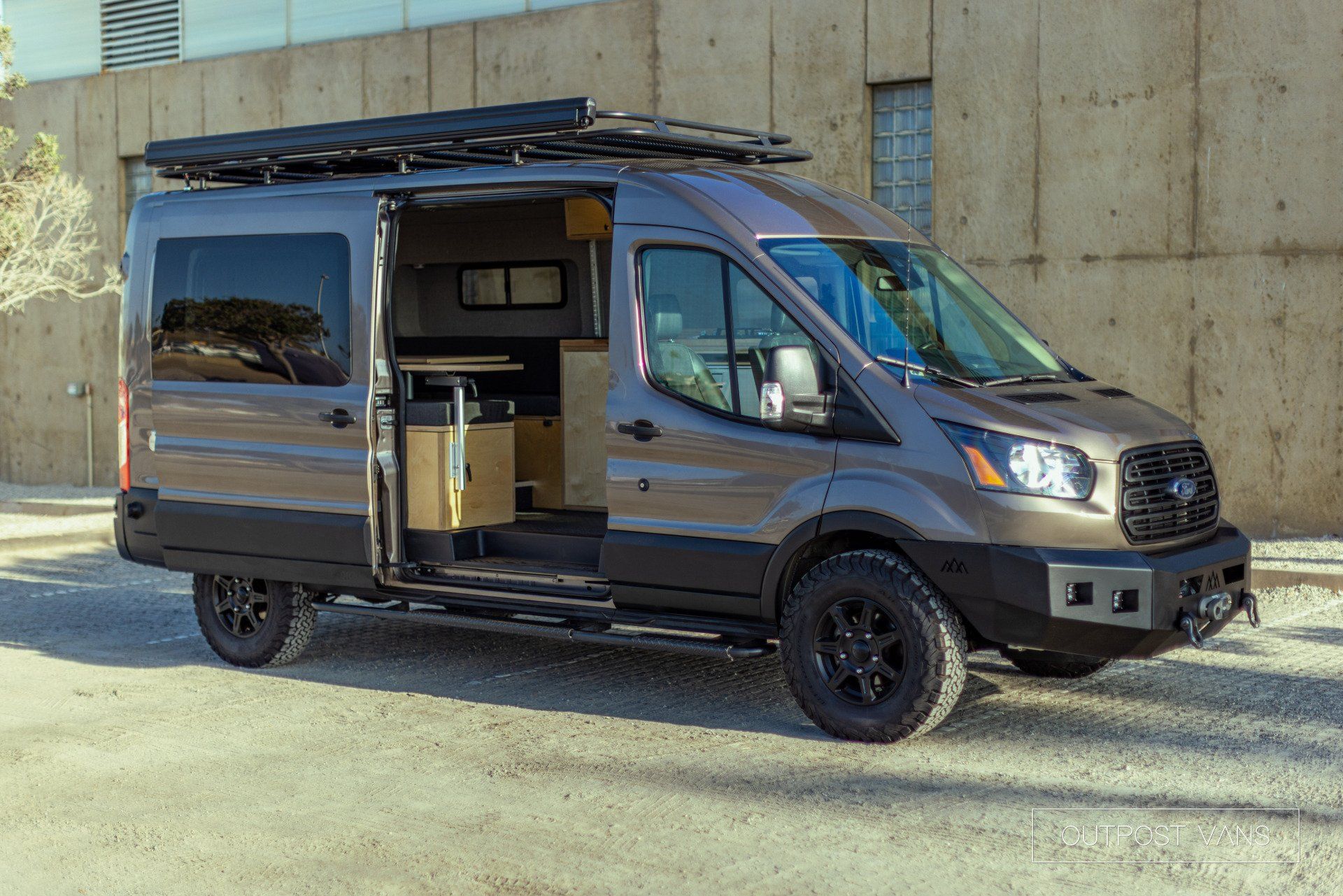 a van is parked in front of a building with its doors open .