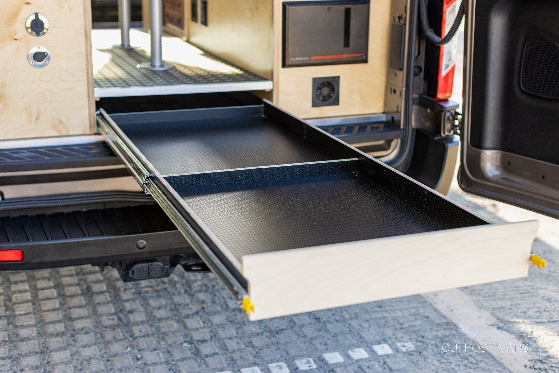 a drawer is pulled out of the back of a van .