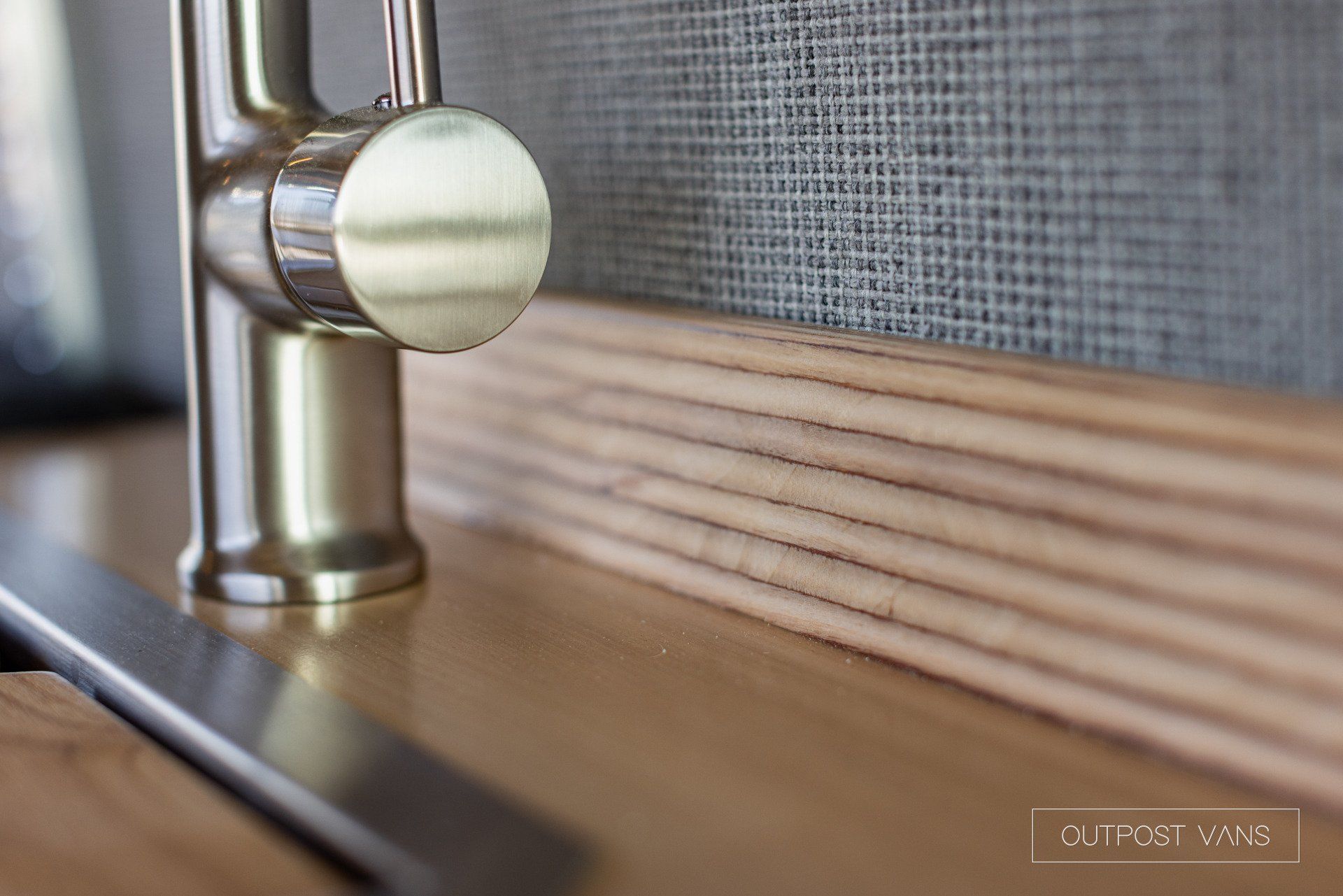 a close up of a faucet on a wooden counter top .