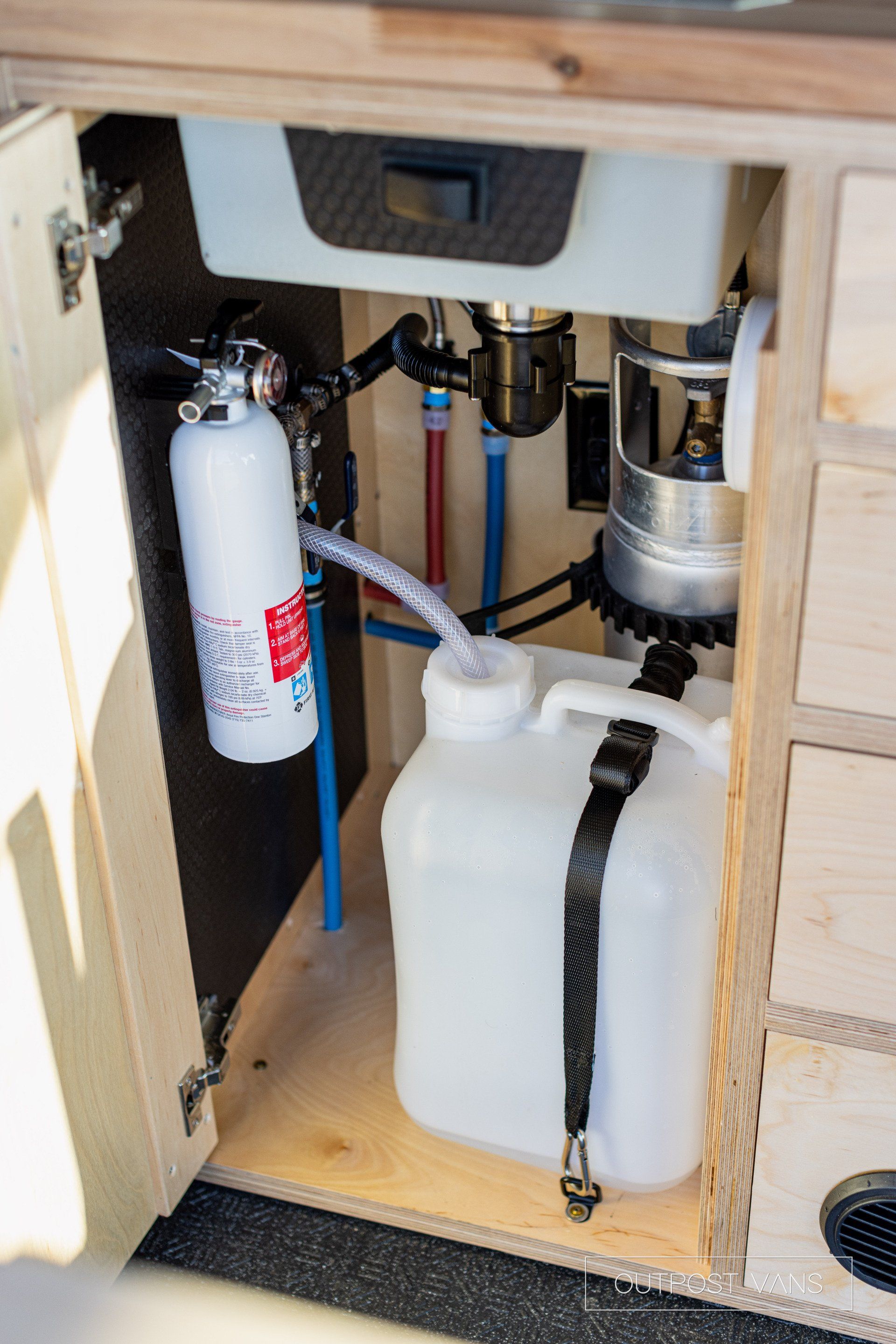 a white container is sitting under a sink in a cabinet .