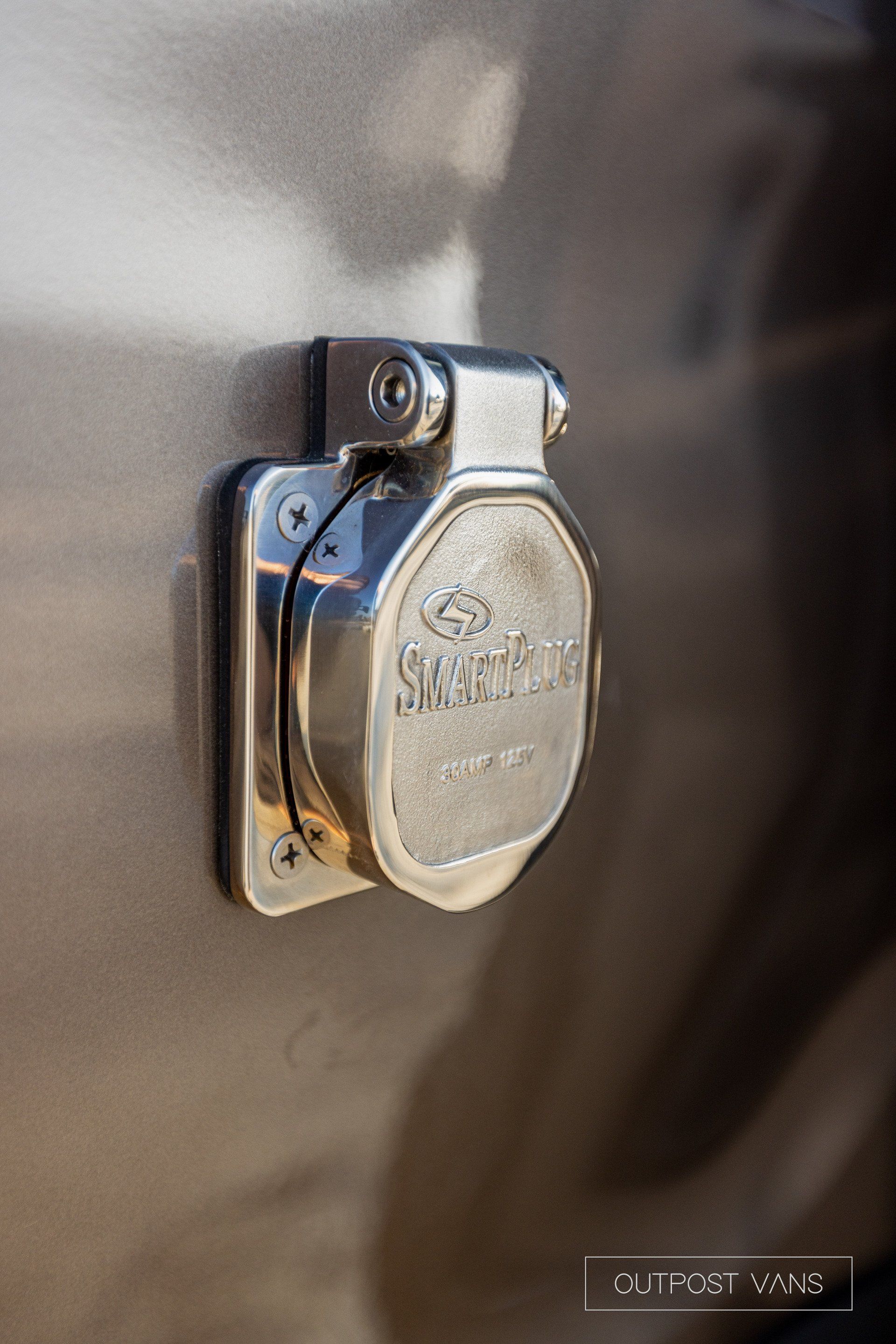 a close up of a stainless steel electrical outlet on the side of a vehicle .