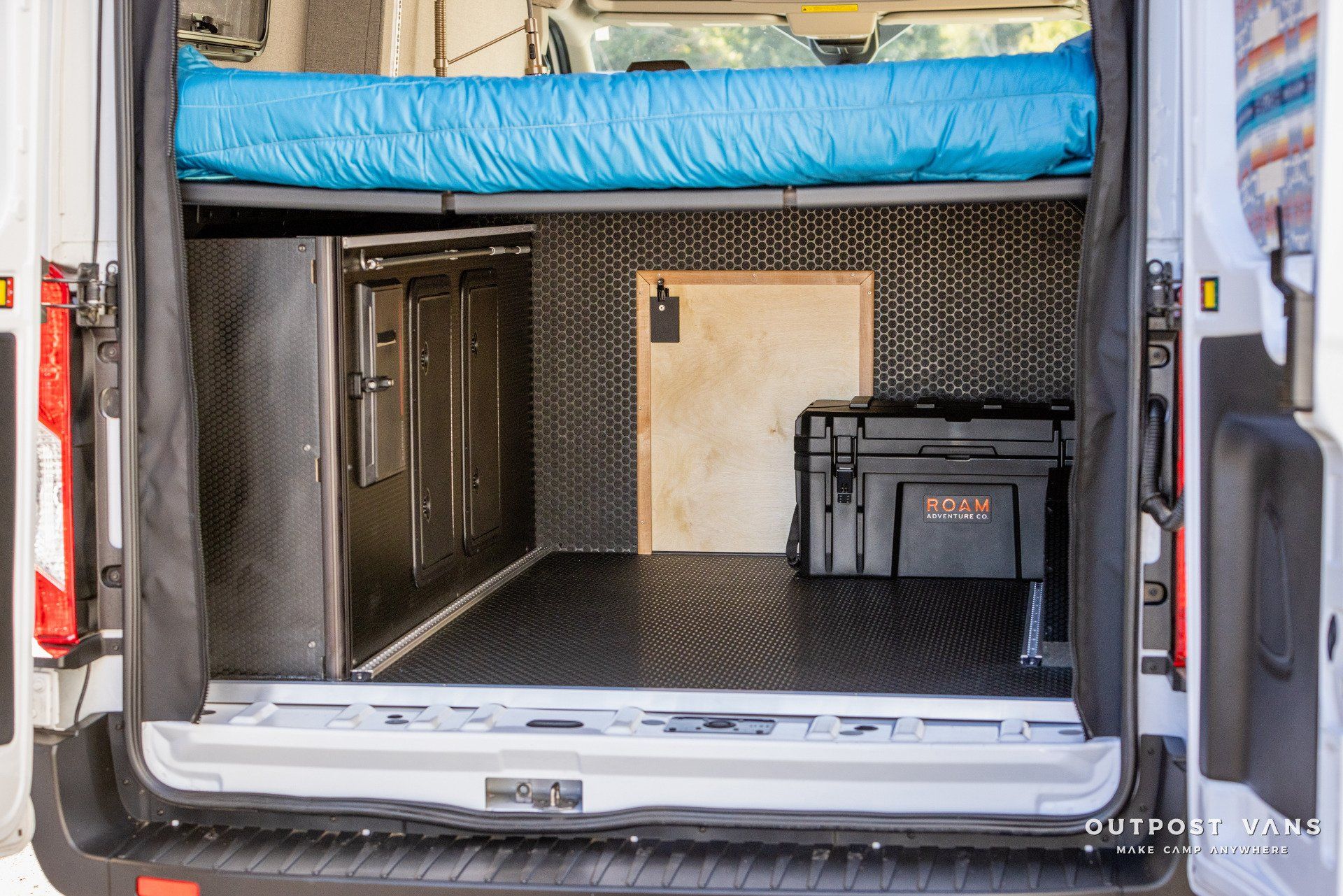 the back of a van with a bed in it .