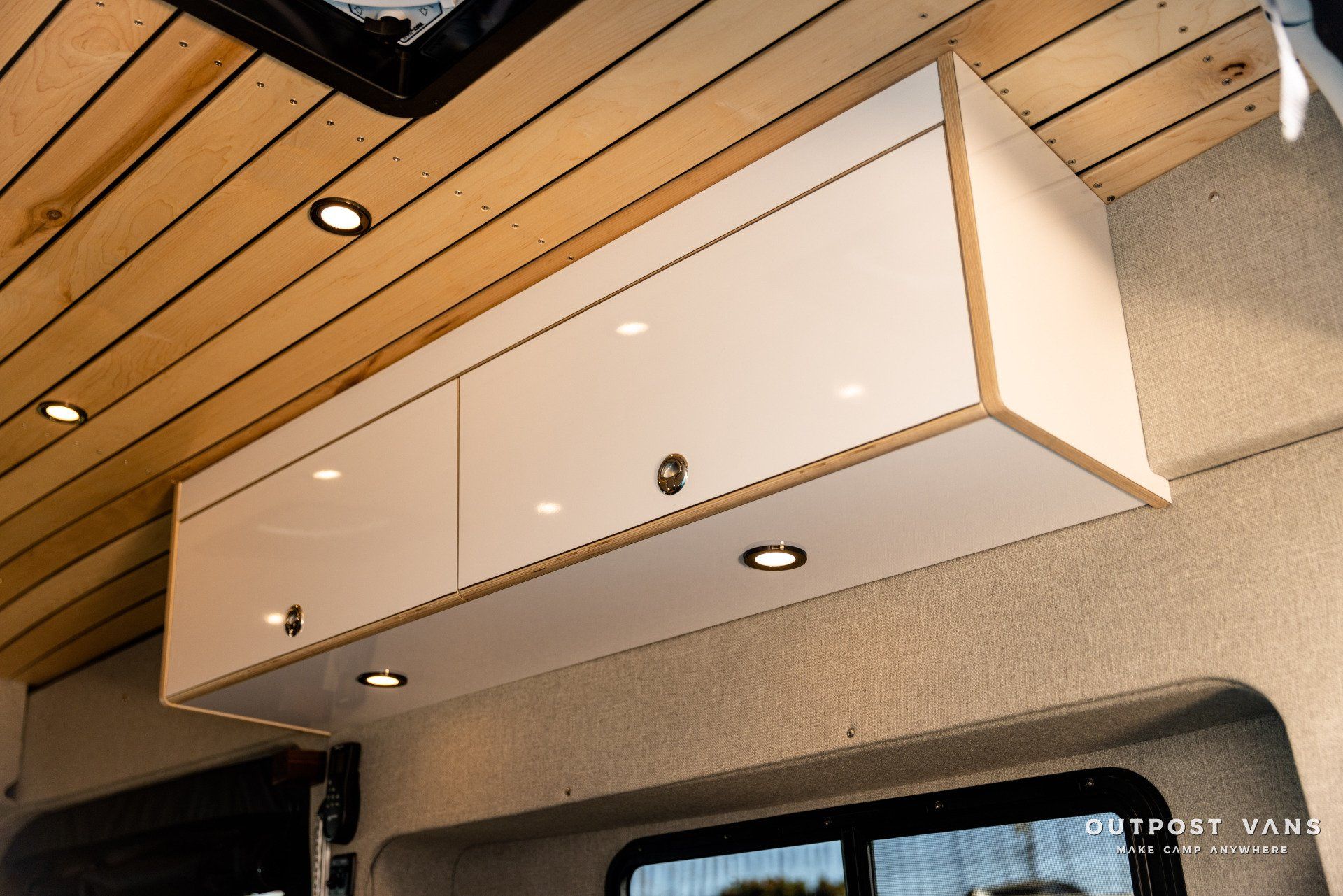 a white cabinet is hanging from the ceiling of a van