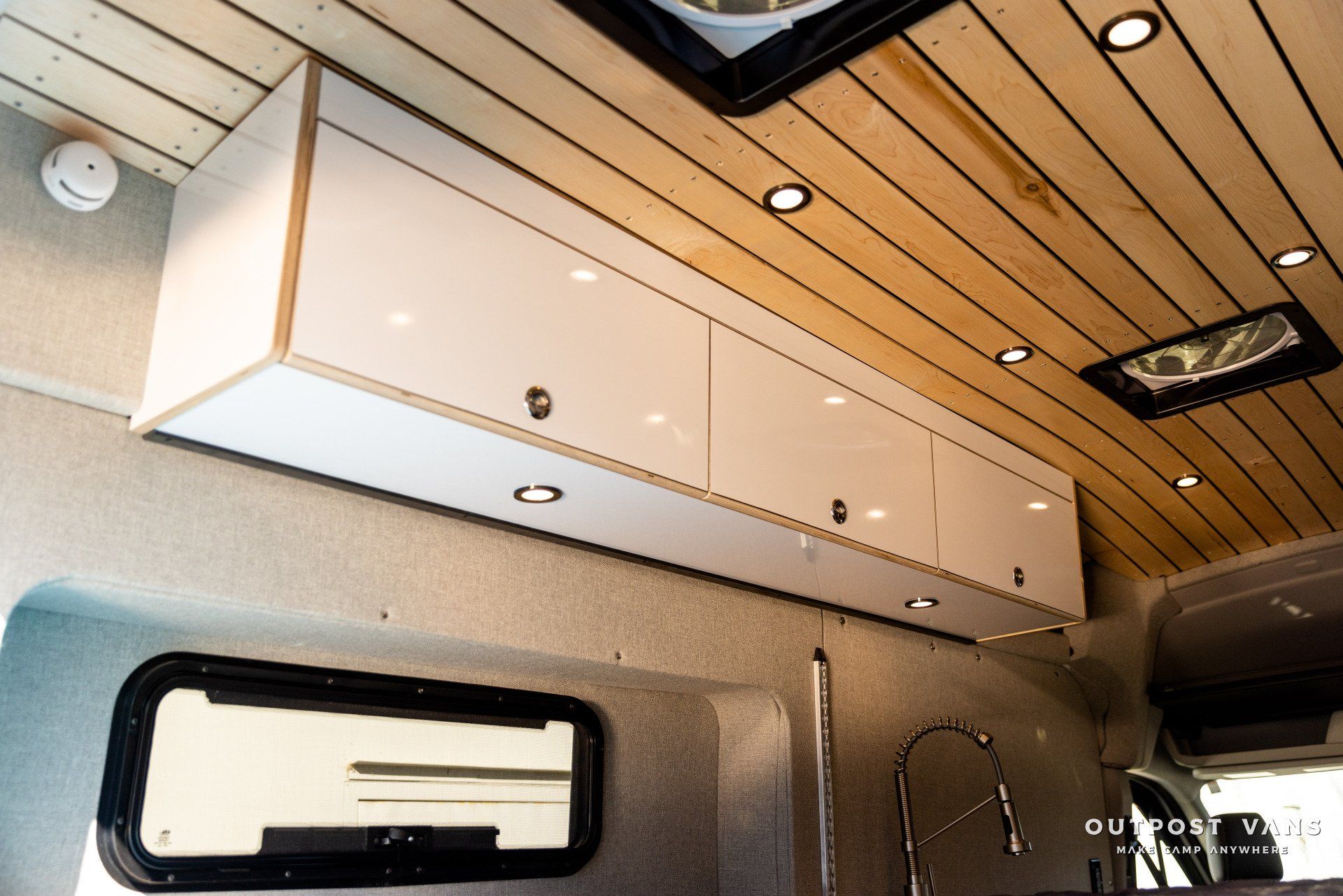 a van with white cabinets and a wooden ceiling