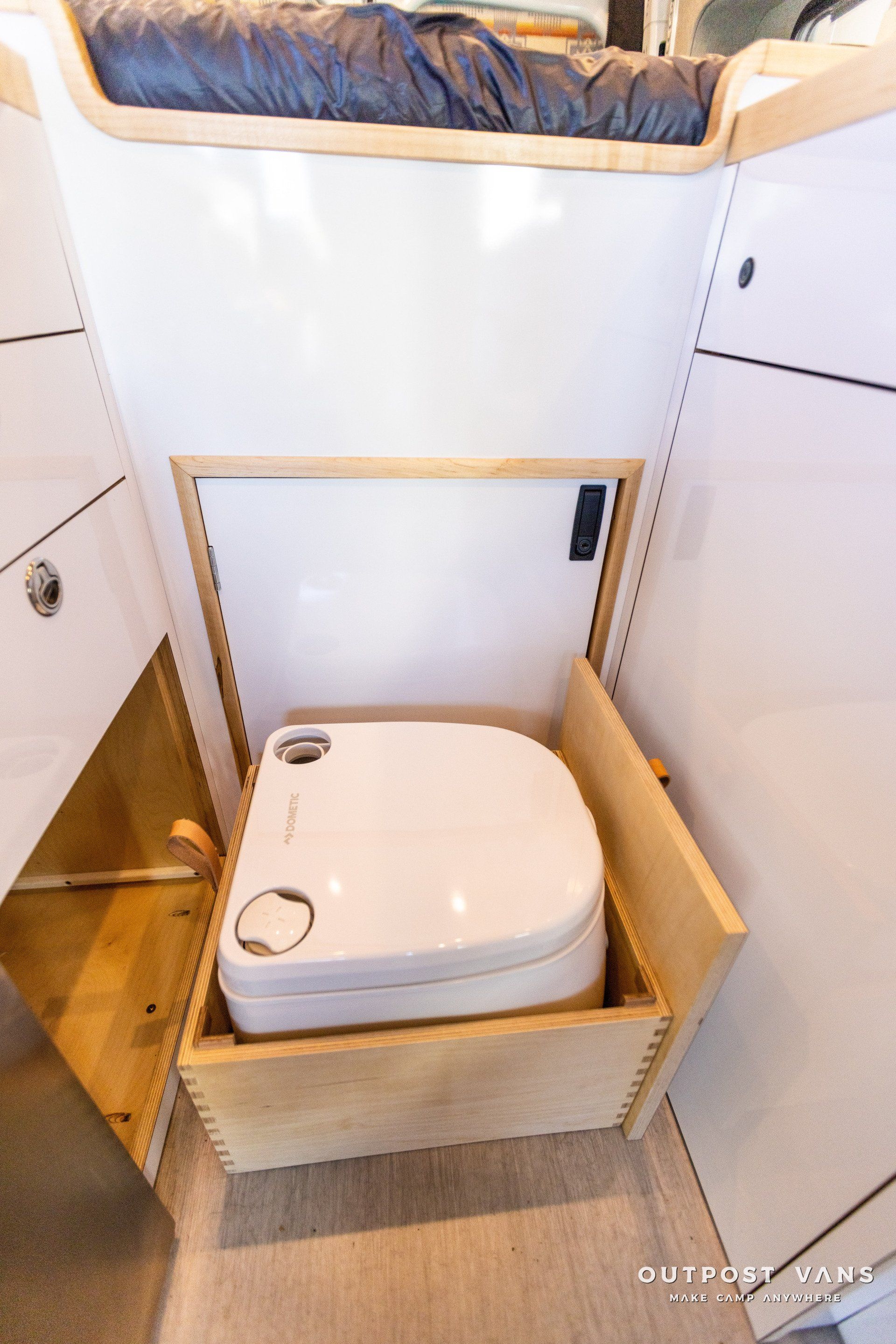 a toilet is sitting in a wooden box in a bathroom .