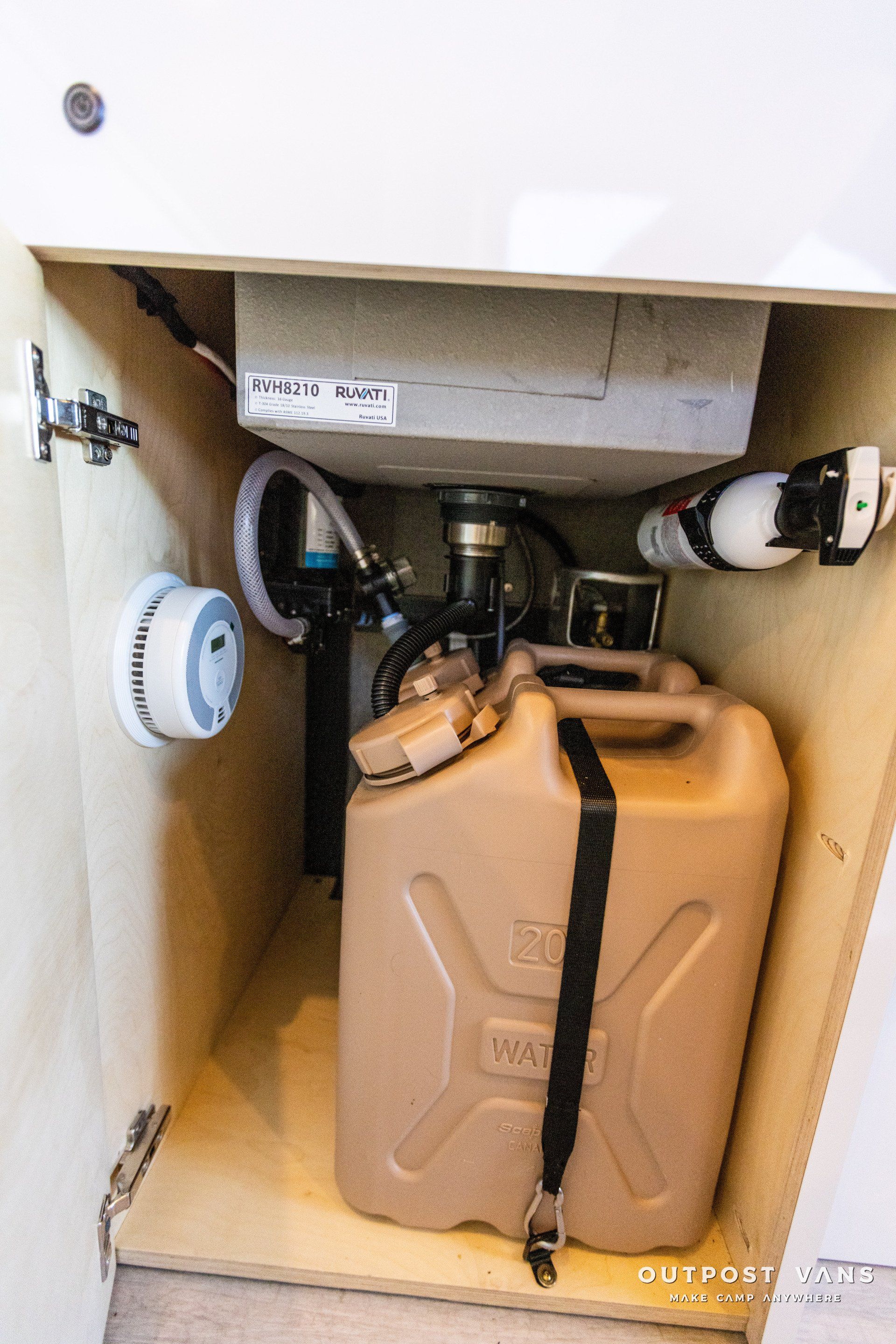 a jerry can is sitting under a sink in a cabinet .