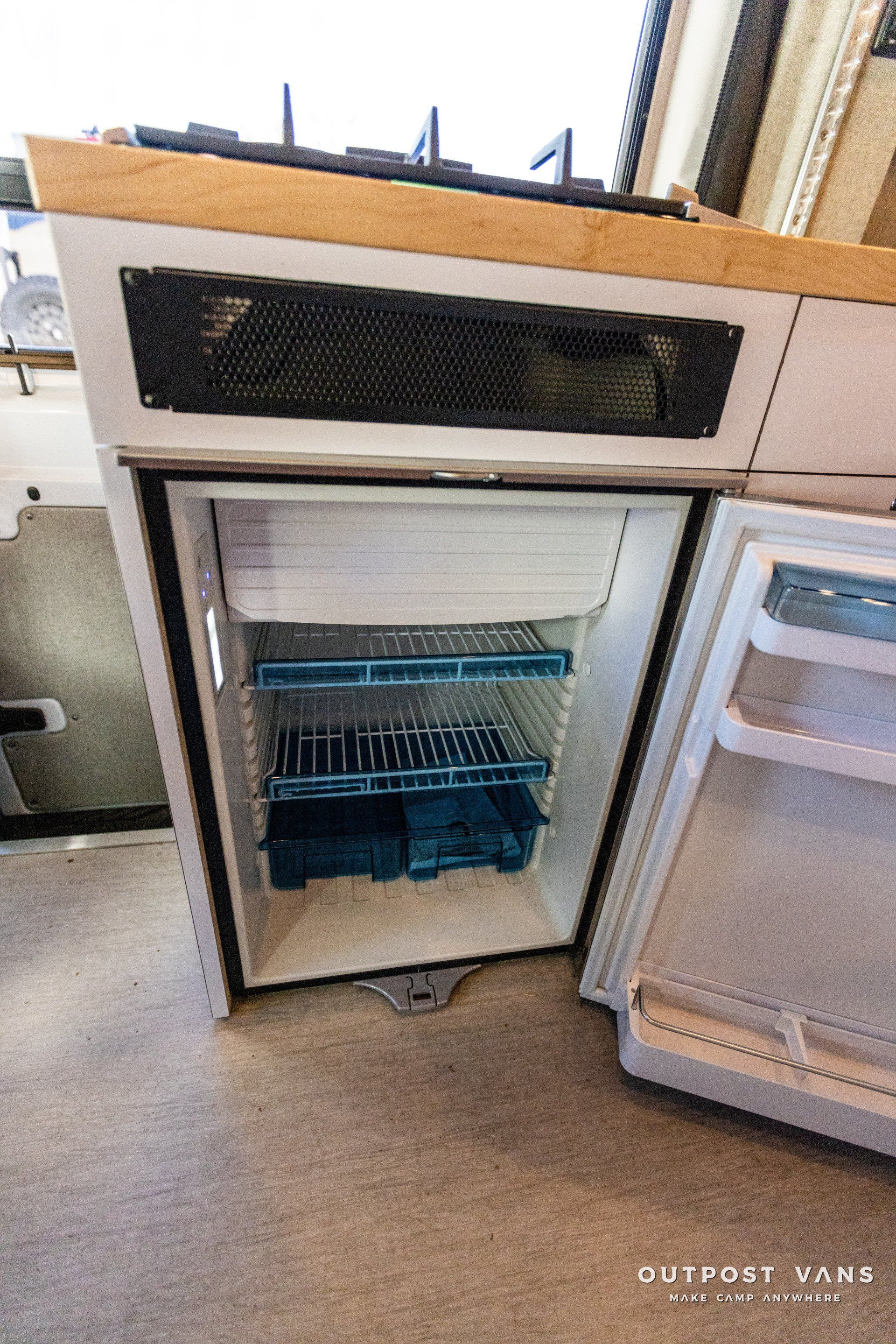 a small refrigerator with the door open in a kitchen .