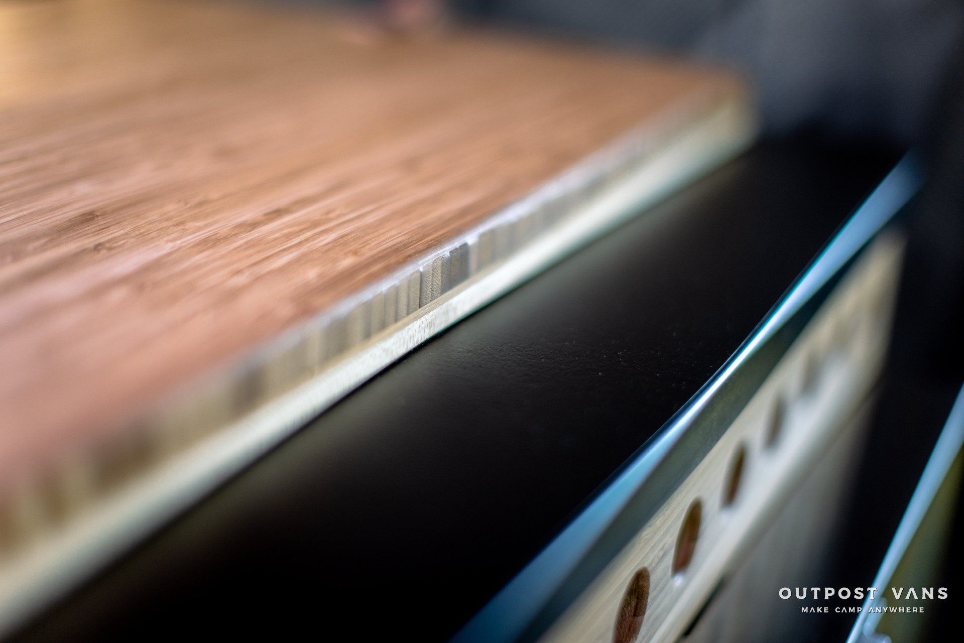 A close up of a wooden table with the words outpost vans on the bottom