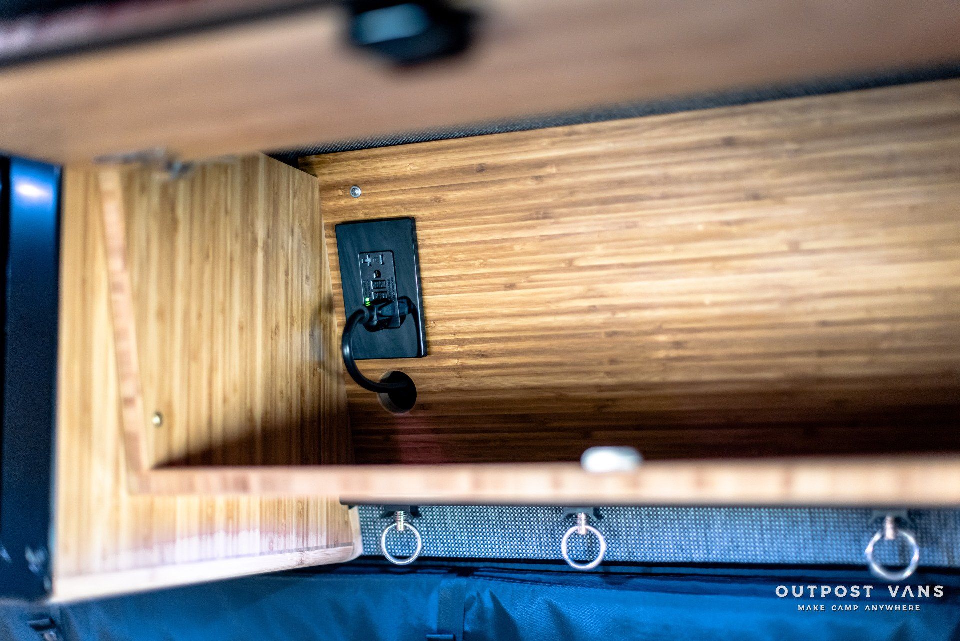 The inside of a van with a shelf and a charger.