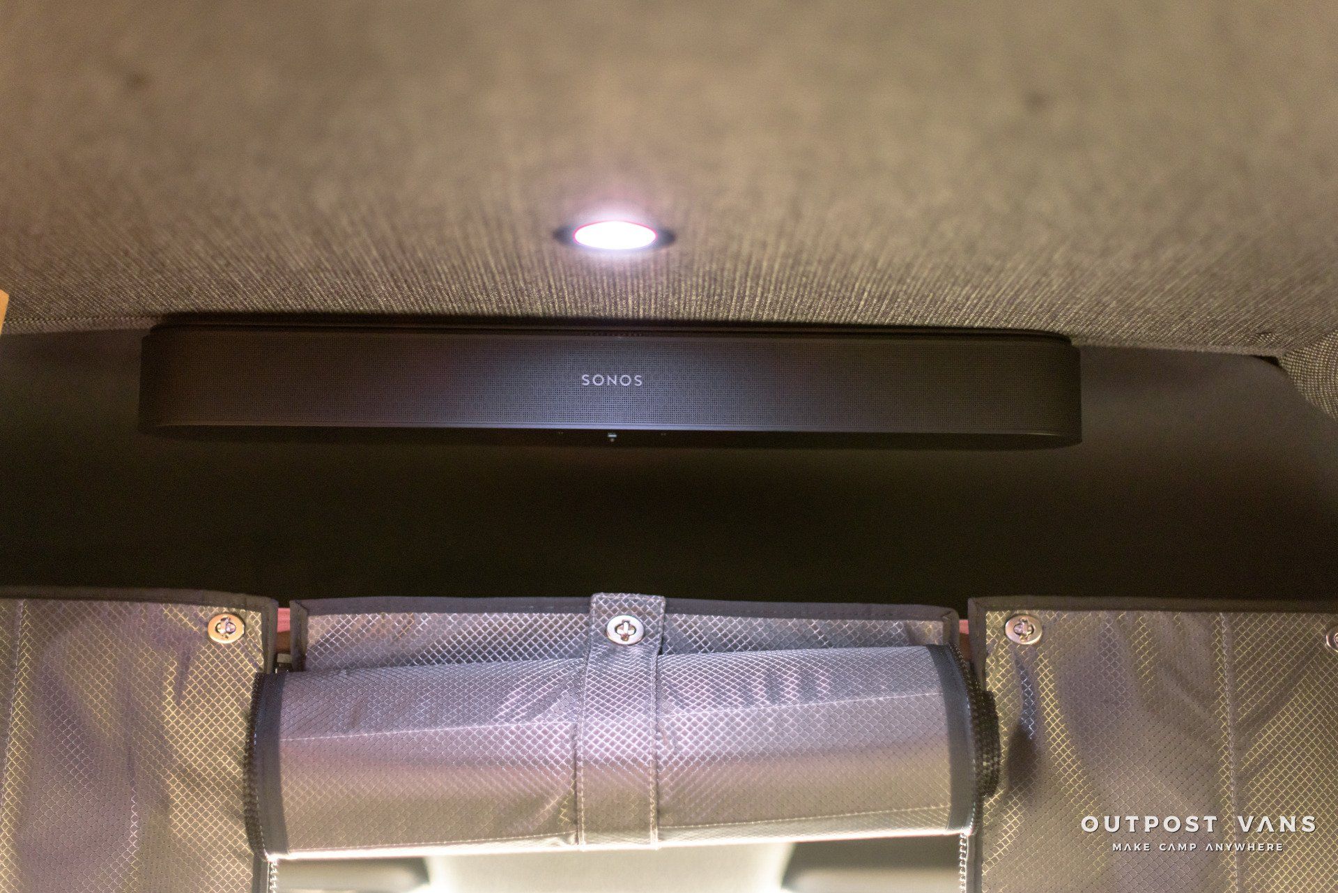 A ceiling with a speaker and a light on it