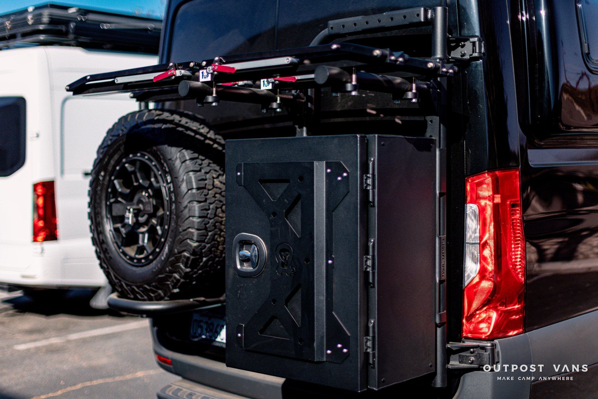 A black van with a spare tire attached to the back of it.
