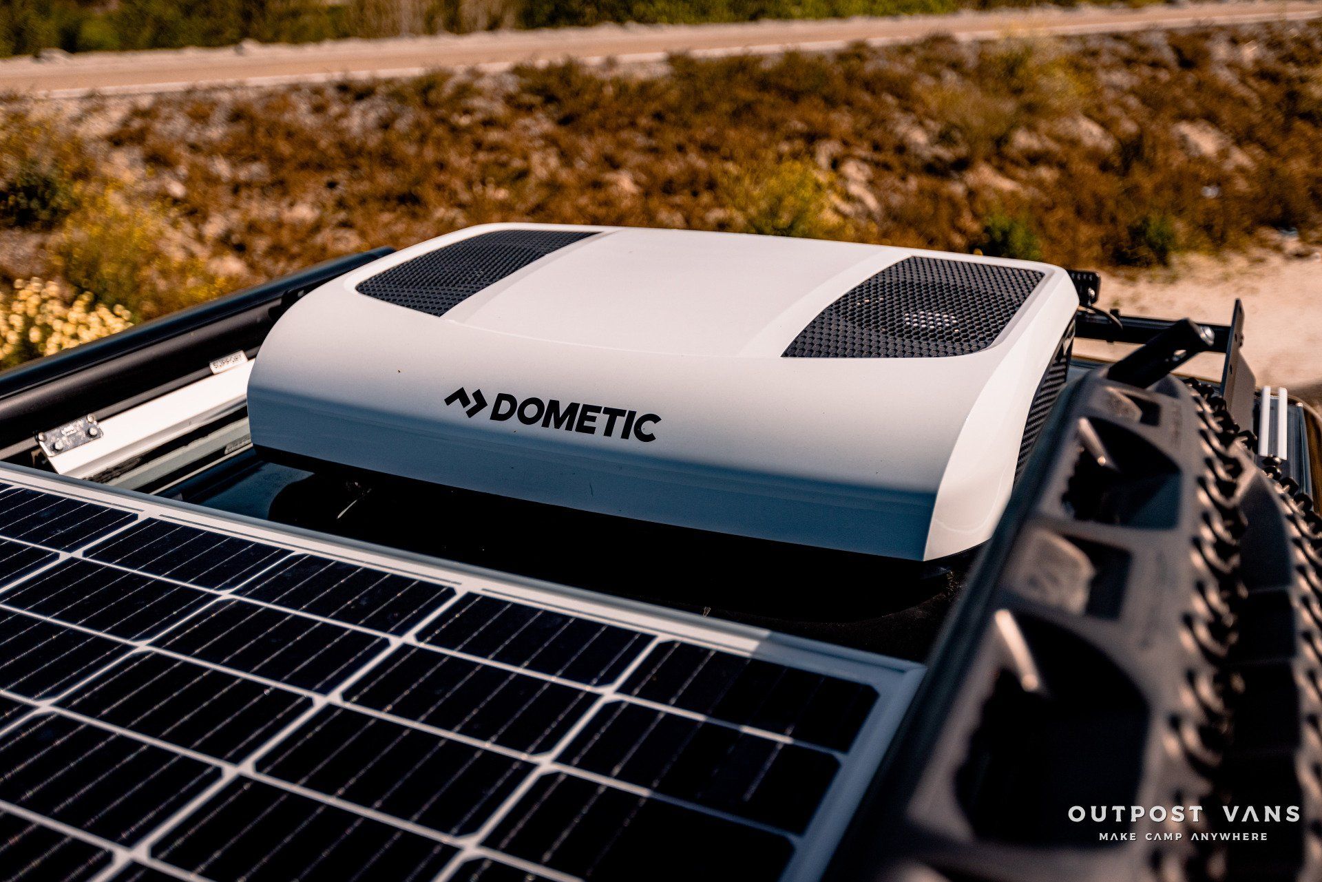 A dometic air conditioner is sitting on top of a solar panel.