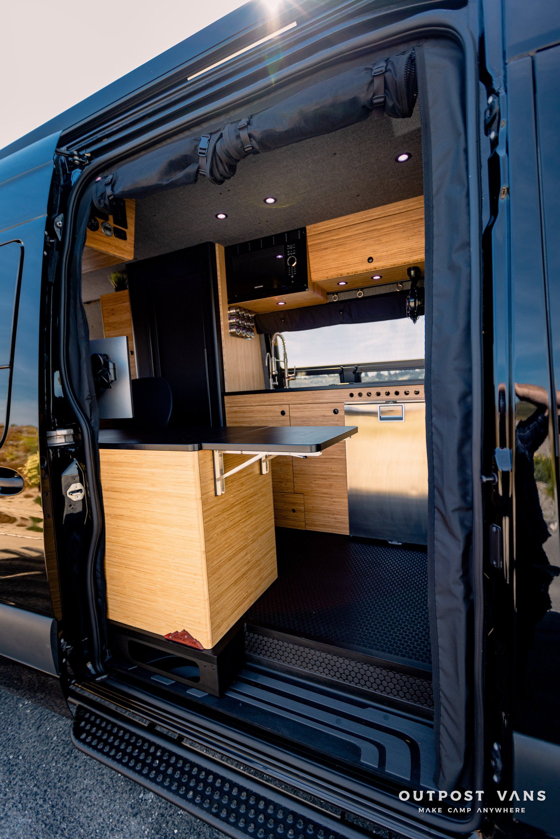 A black van with a table in the back of it.