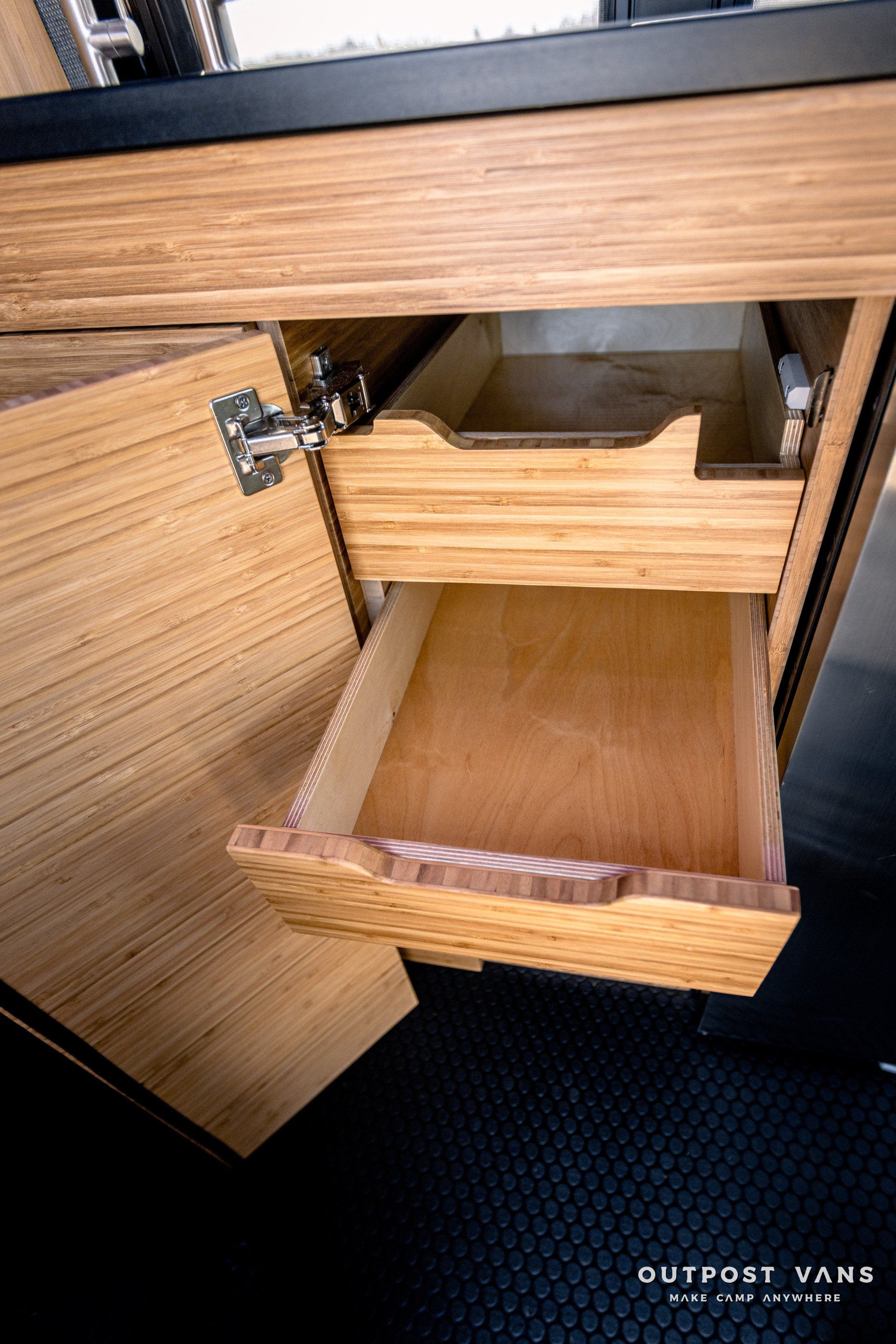 A wooden drawer is open in a wooden cabinet.