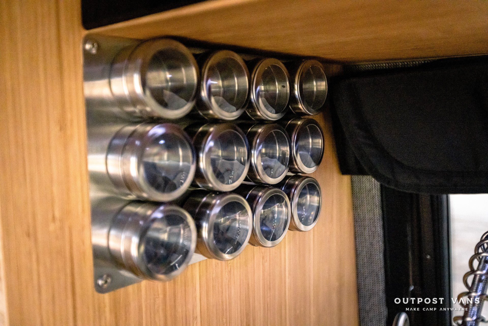 A bunch of metal cans are stacked on top of each other on a wooden wall.