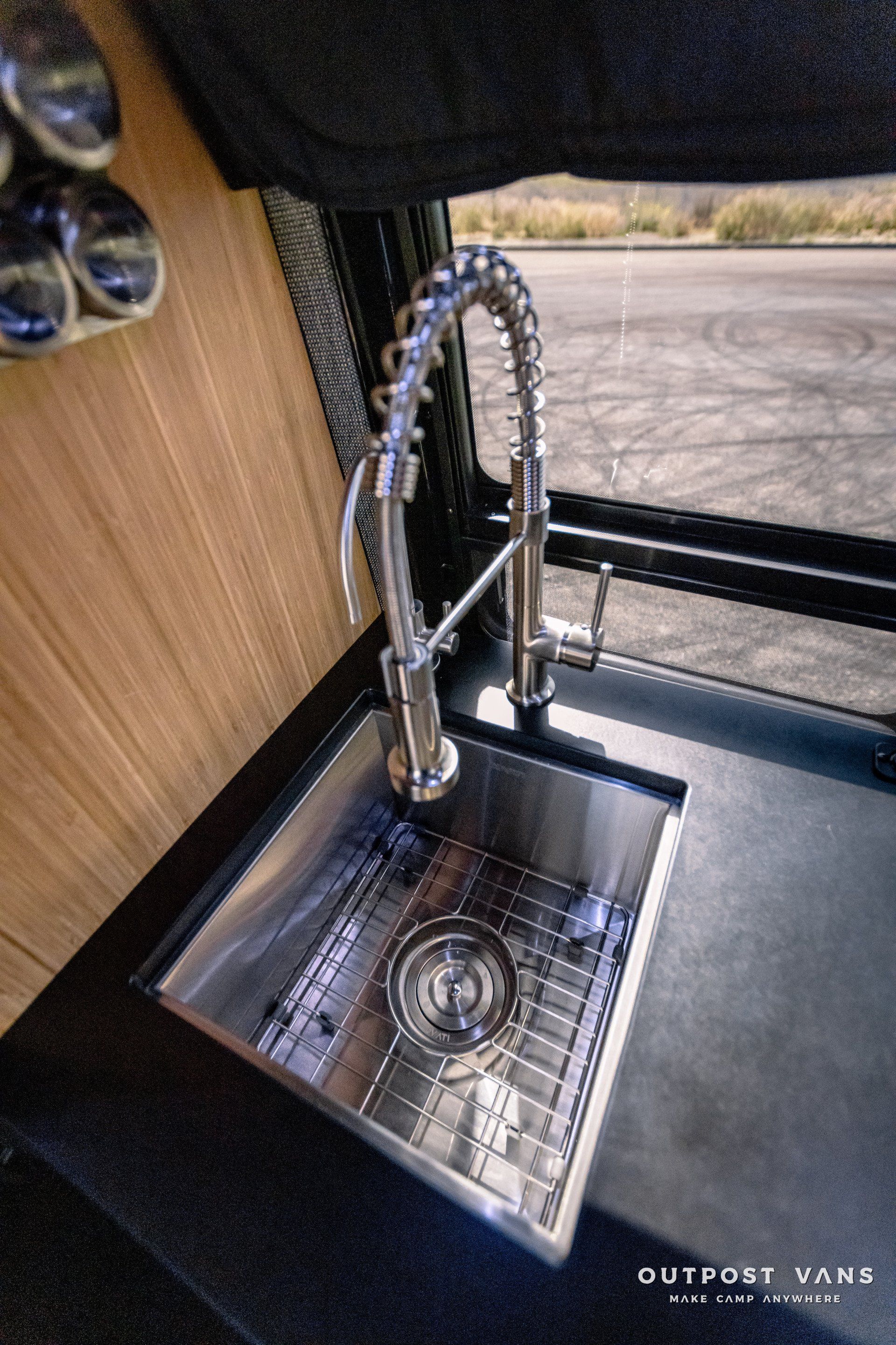 A stainless steel sink with a faucet in a van.
